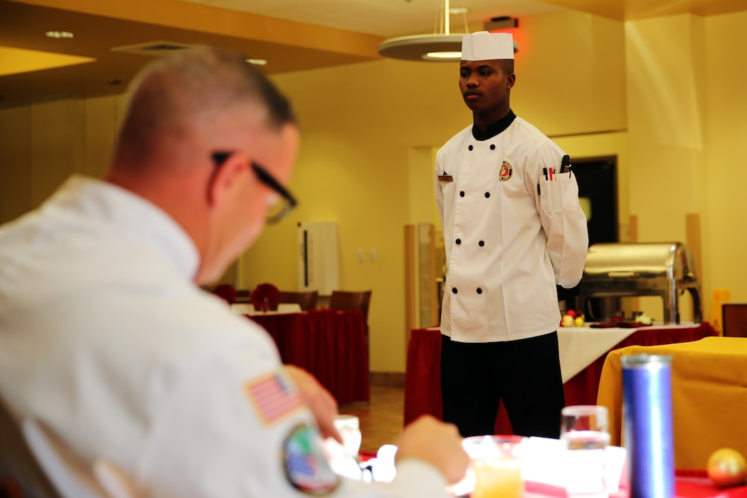 Lance Cpl. Jaylen M. Thomas stands at rest while judges critique his meal during the Chef of the Quarter competition at Marine Corps Air Station Cherry Point, N.C., Dec. 12, 2014. Thomas prepared the winning meal of fried chicken, dirty mashed potatoes, sweet cream corn, asparagus and fried Oreos. Thomas, a native of Atlanta, is a food service specialist with Headquarters and Headquarters Squadron.