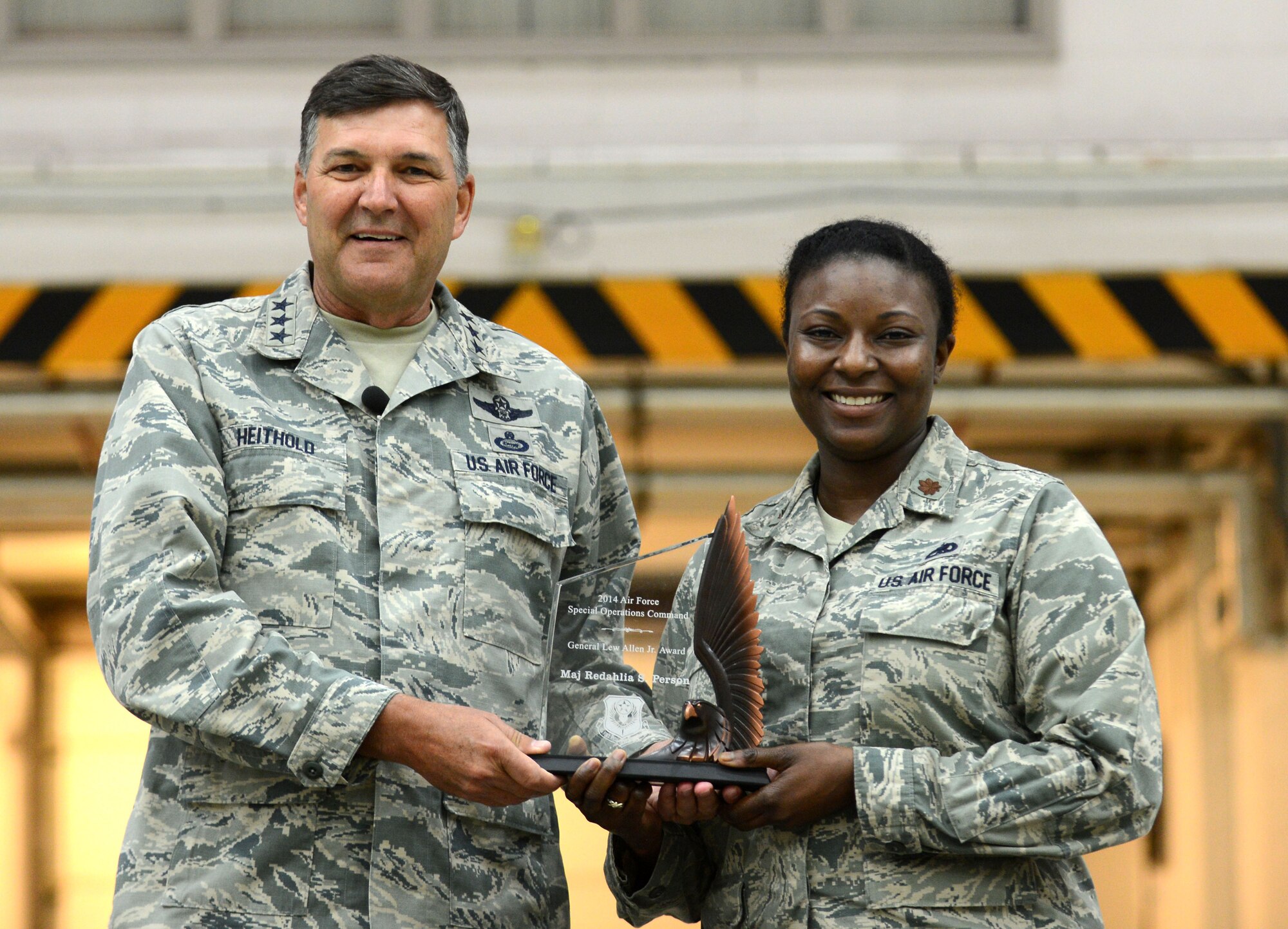 Lt. Gen. Brad Heithold, commander of Air Force Special Operations Command, congratulates Maj. Redahlia Person, 352nd Special Operations Maintenance Squadron maintenance operations officer, on becoming the Air Force-level recipient of the 2014 Gen. Lew Allen Jr. Trophy. The trophy is awarded annually to a base-level maintenance officer and senior NCO with outstanding contributions to sortie generation. After being recognized at the base level, nominees continue to compete at the major command and then Air Force level. (U.S. Air Force photo by Senior Airman Katherine Maurer/Released)
