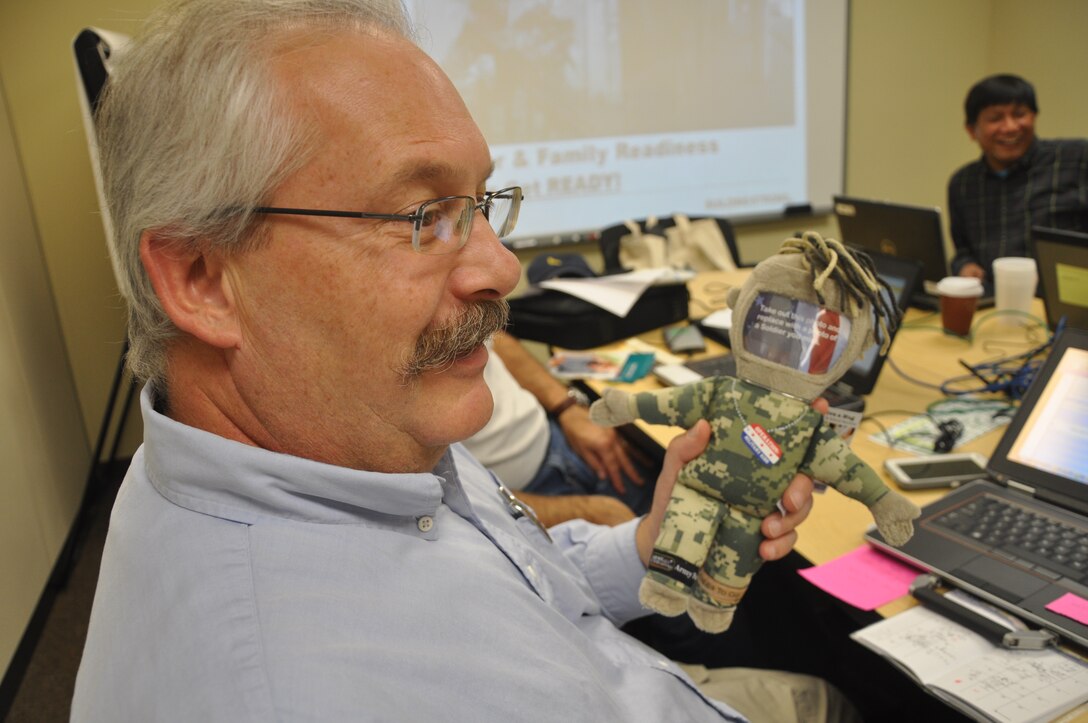 Zsolt Haverland, 542nd FEST-A environmental engineer, receives an Operation Give a Hug Doll from the Family Readiness Network office during a pre-deployment briefing Nov. 21. The doll has the benefit of allowing friends and family members to insert a picture of their deployed loved one and take their doll wherever they venture. The dolls support the element to pre-deployment and deployment emotions, according to Paula Hanna, FRN coordinator.
