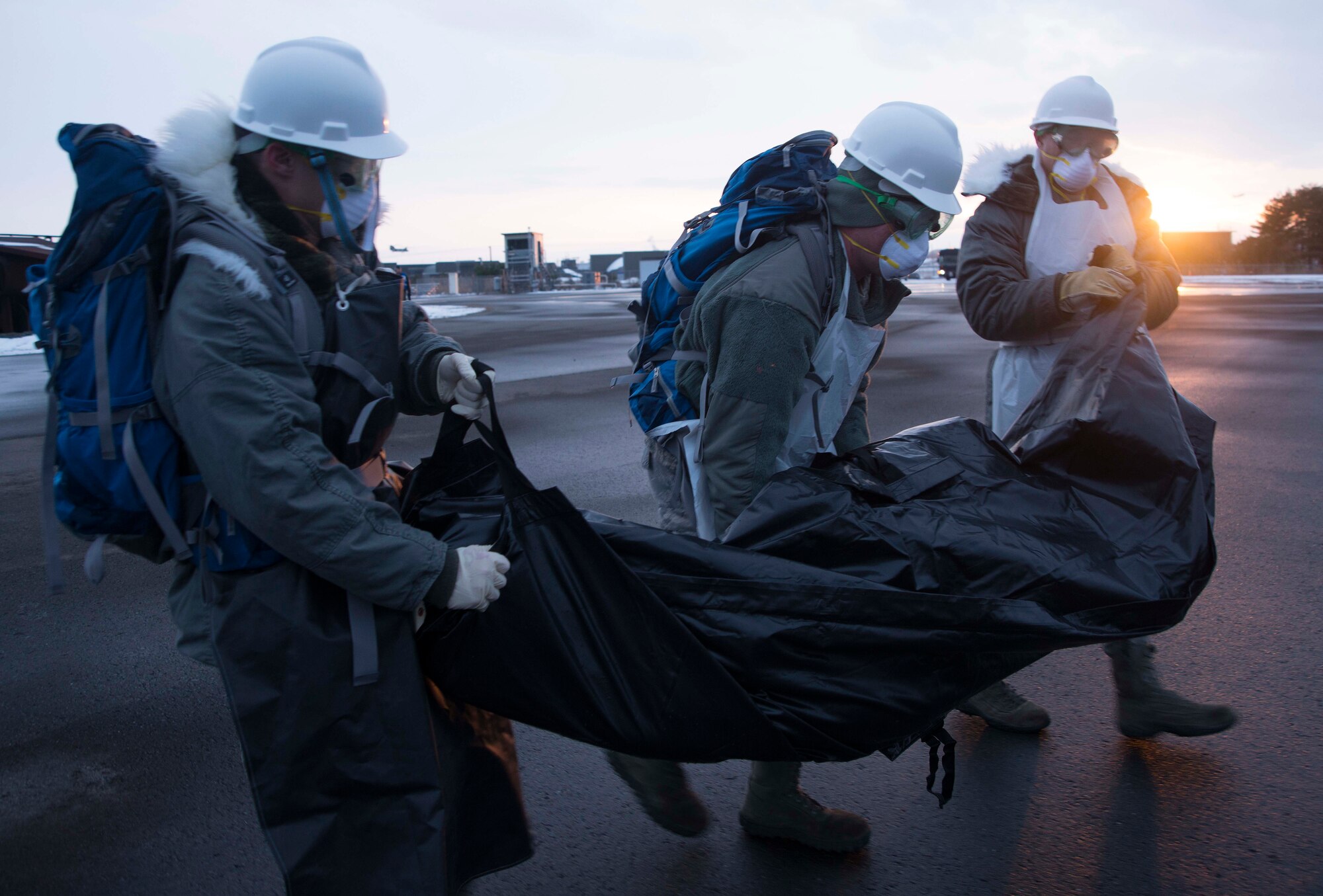 Airmen from the 35th Force Support Squadron carry a simulated body during a search and recovery mission Dec. 10, 2014, at Misawa Air Base, Japan. After a simulated C-130 Hercules crashed, base agencies were dispatched to the scene where their response and recovery abilities were tested during exercise Beverly Sunrise 15-1. (U.S. Air Force photo/Staff Sgt. Derek VanHorn)