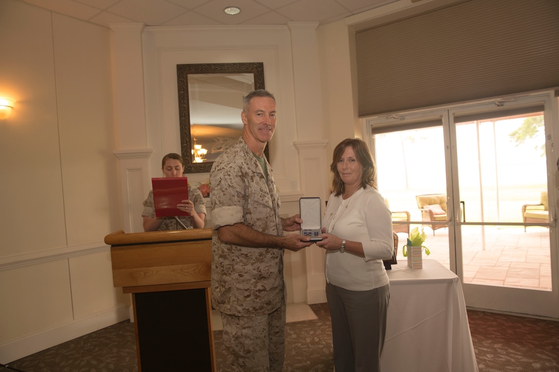 Col. Timothy Salmon, the commanding officer of Marine Corps Air Station New River, stands with Kathy Zerba, his former office management specialist and community liaison coordinator, after she was recognized with the meritorious civilian service award during a surprise farewell celebration in her honor, at the Eagles Nest Officers’ Club aboard Marine Corps Air Station New River, July 10. Zerba is joining the staff of Naval Hospital Camp Lejeune after nine years of service at MCAS New River.