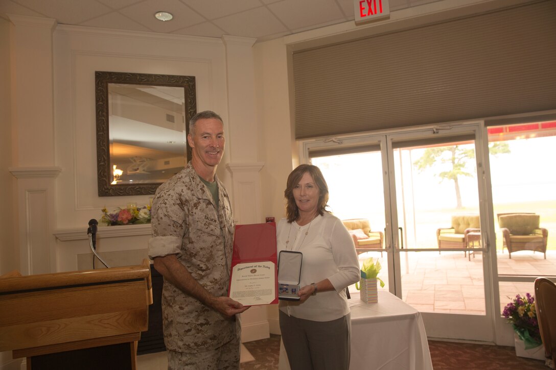 Col. Timothy Salmon, the commanding officer of Marine Corps Air Station New River, stands with Kathy Zerba, his former office management specialist and community liaison coordinator, after she was recognized with the meritorious civilian service award during a surprise farewell celebration in her honor, at the Eagles Nest Officers’ Club aboard Marine Corps Air Station New River, July 10. Zerba is joining the staff of Naval Hospital Camp Lejeune after nine years of service at MCAS New River.