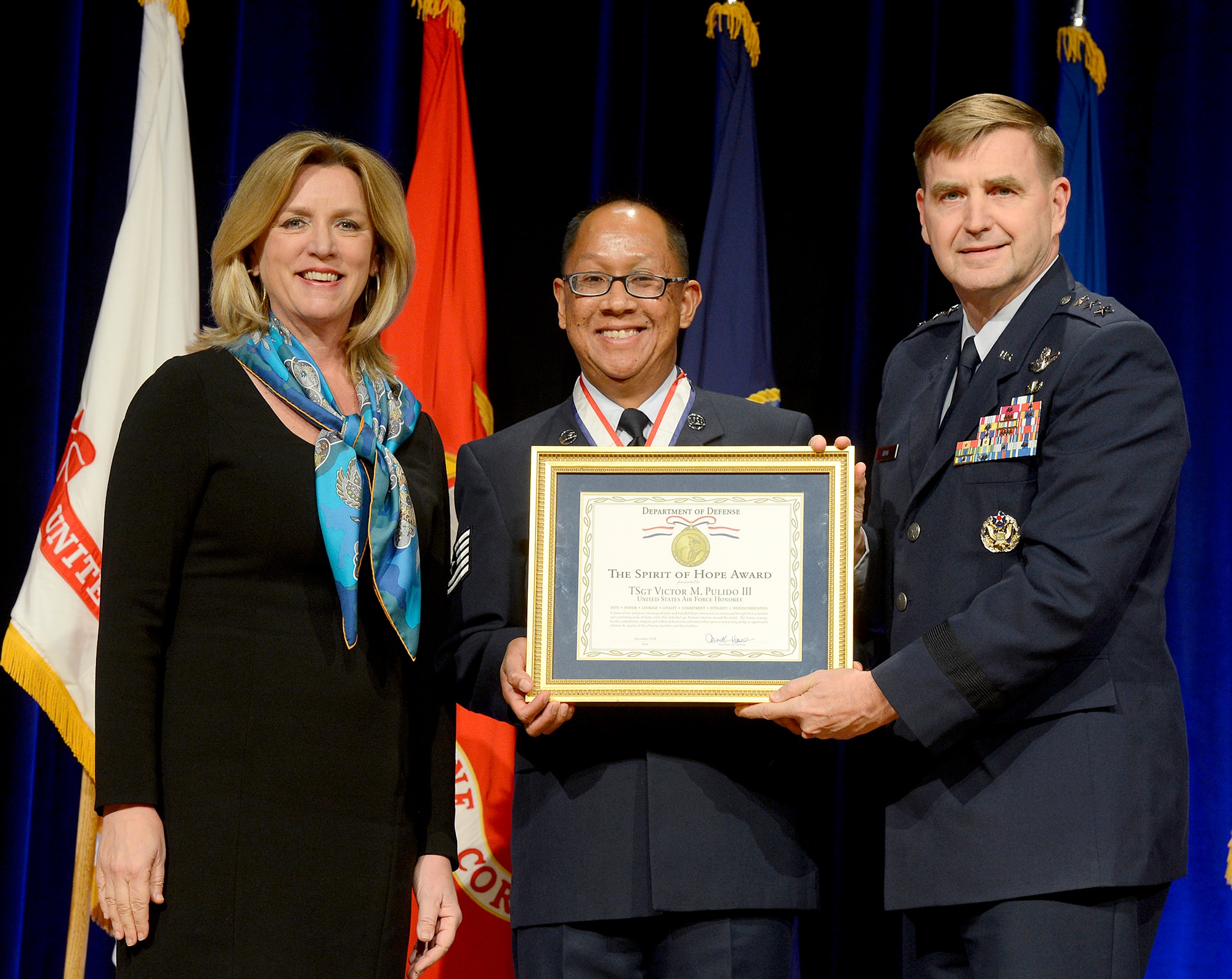 Secretary of the Air Force Deborah Lee James and Air Force Assistant Vice Chief of Staff Lt. Gen. Stephen Hoog present retired Tech. Sgt. Victor Pulido III the Spirit of Hope Award during a ceremony in the Pentagon, Dec. 11, 2014.  The award is presented to individuals or organizations from each of the military services whose patriotism and service to members of the U.S. Armed Forces reflects the patriotism and service of Bob Hope.  (U.S. Air Force photo/Scott M. Ash)   