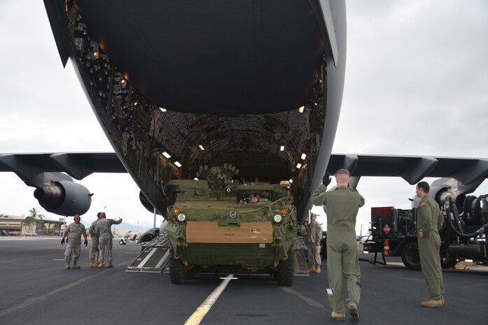 JOINT BASE PEARL HARBOR-HICKAM, Hawaii (Dec. 10, 2014) - Airman 1st Class Sean Bannan (middle right), from Seattle, Wash., a load master assigned to 535th Airlift Squadron, 15th Wing, ground guides a M1126 Stryker onto a C-17 aircraft to support of the 25th ID Contingency Response Force mission (CRF). The CRF mission is designed to rapidly deploy Soldiers within the Pacific's area of responsibility to provide humanitarian assistance and or combat operations.   141210-A-ZZZ00-695
