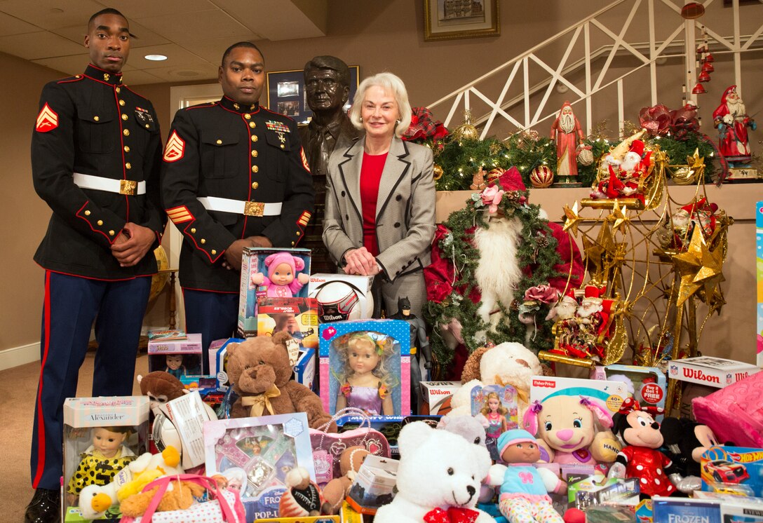Cpl. Joshua A. Pineset (left), the security administrative noncommissioned officer in charge at Marine Forces Reserve, and Staff Sgt. Sylvester T. Dollard (center), the security administrative Staff NCOIC at MARFORRES, receive toys from Phyllis M. Taylor (right) at the Patrick F. Taylor Foundation building in New Orleans, Dec. 16, 2014. The toys were donated by employees of the foundation to support the Marine Corps Reserve’s Toys for Tots program.