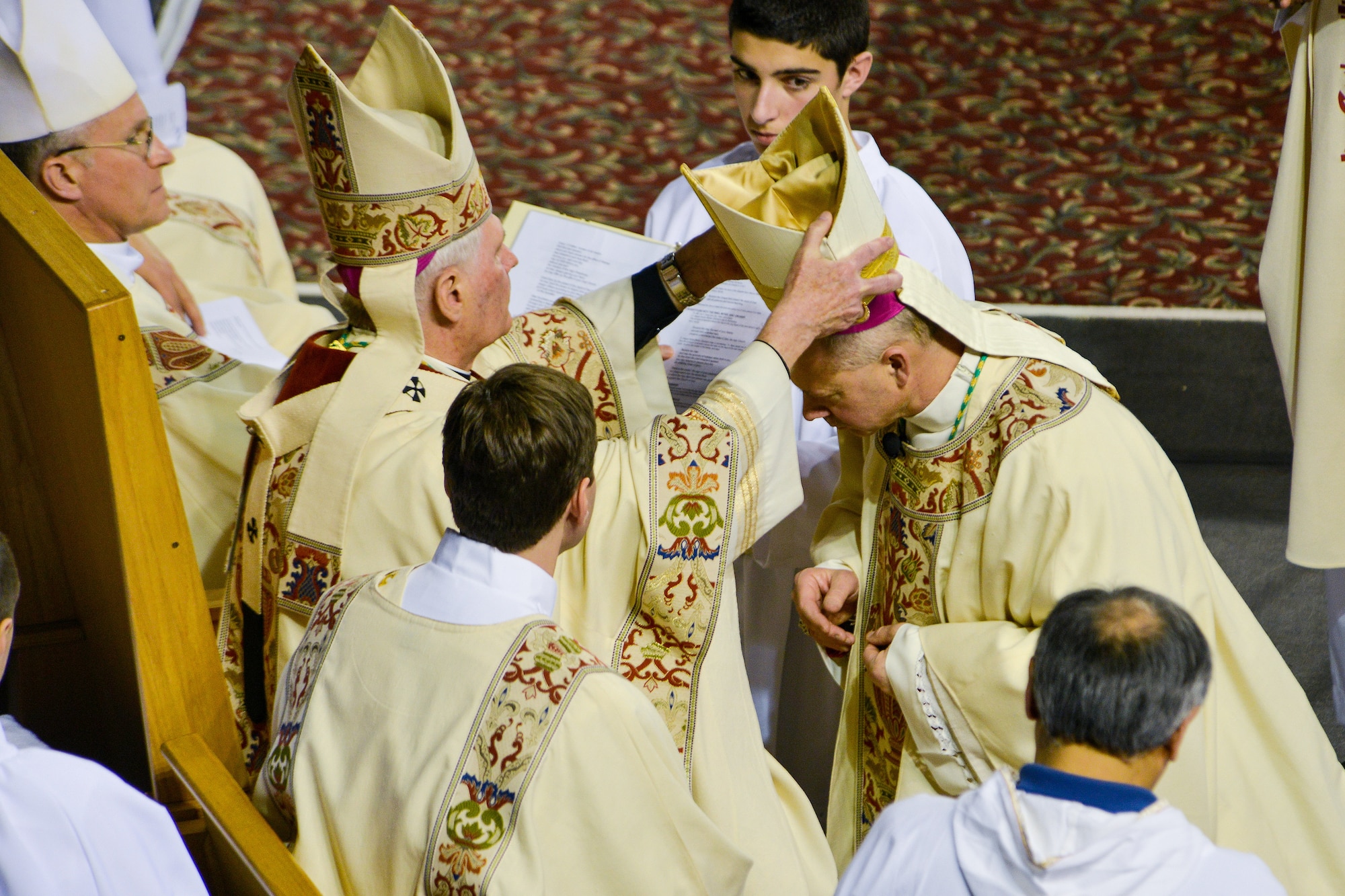 The Rev. Roger L. Schwietz, Archbishop of Anchorage, Alaska, places a miter on the head of Chaplain (Maj.) Chad Zielinski, the 354th Fighter Wing deputy wing chaplain, ordaining Zielinski the bishop of the Fairbanks Catholic diocese Dec. 15, 2014, at the Carlson Center, Fairbanks, Alaska. Zielinski will be responsible for overseeing Catholic interests in an area the size of Texas, much of which isn't accessible by road. (U.S. Air Force photo/Tech. Sgt. Joseph Swafford)