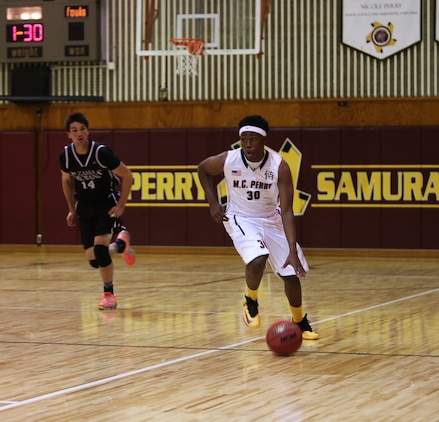 Jarell Davis, a senior with the Matthew C. Perry Samurai basketball team, dribbles the ball up the court during the first of two home games against the Zama American High School Trojans, Dec. 12, 2014, at the high school gymnasium aboard Marine Corps Air Station Iwakuni, Japan. The Samurai defeated the Trojans 45-28 in the first game and 59-54 in the second. 