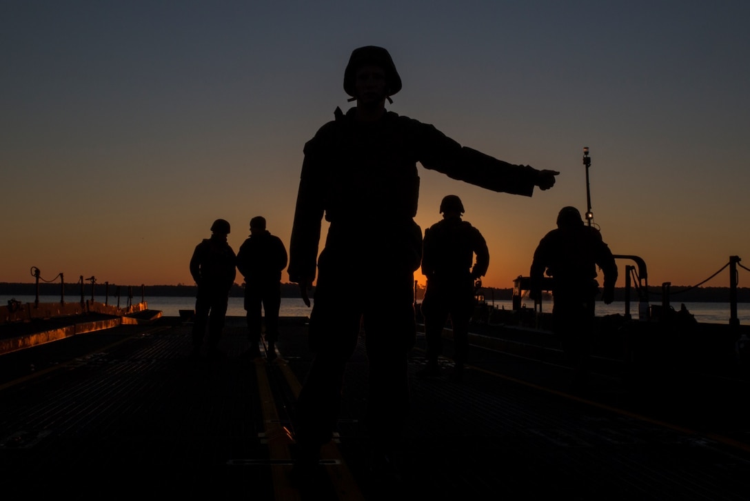 Lance Cpl. Walker Vance, a motor transport Marine with Bridge Company, 8th Engineer Support Battalion guides a boat attached to an Improved Ribbon Bridge aboard Marine Corps Base Camp Lejeune, N.C., December 14, 2014. Marines with the unit conducted river crossing exercises in which they transported M1A1 Abrams tanks across New River. (U.S. Marine Corps photo by Lance Cpl. Preston McDonald/Released)