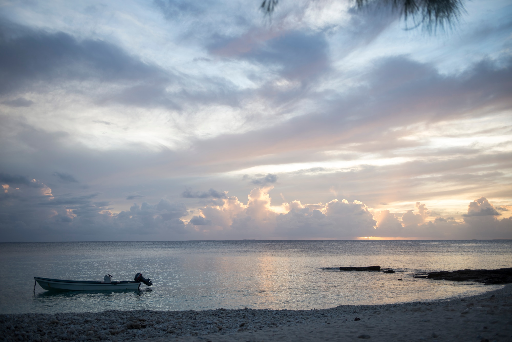 A boat sits under the setting sun at Ulithi Atoll, Micronesia, Dec. 9, 2014. Four islands of 40 in the atoll are inhabited and received goods during Operation Christmas Drop 2014. (U.S. Air Force photo by Staff Sgt. Cody H. Ramirez/Released)