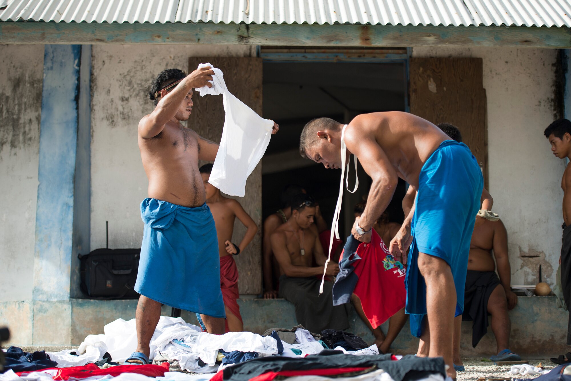 Islanders sort through shirts that were received from an airdropped bundle during Operation Christmas Drop at Ulithi Atoll, Micronesia, Dec. 9, 2014. Shirts are used by the islanders for long fishing trips or when traveling to distant islands to prevent sun burns. (U.S. Air Force photo by Staff Sgt. Cody H. Ramirez/Released)