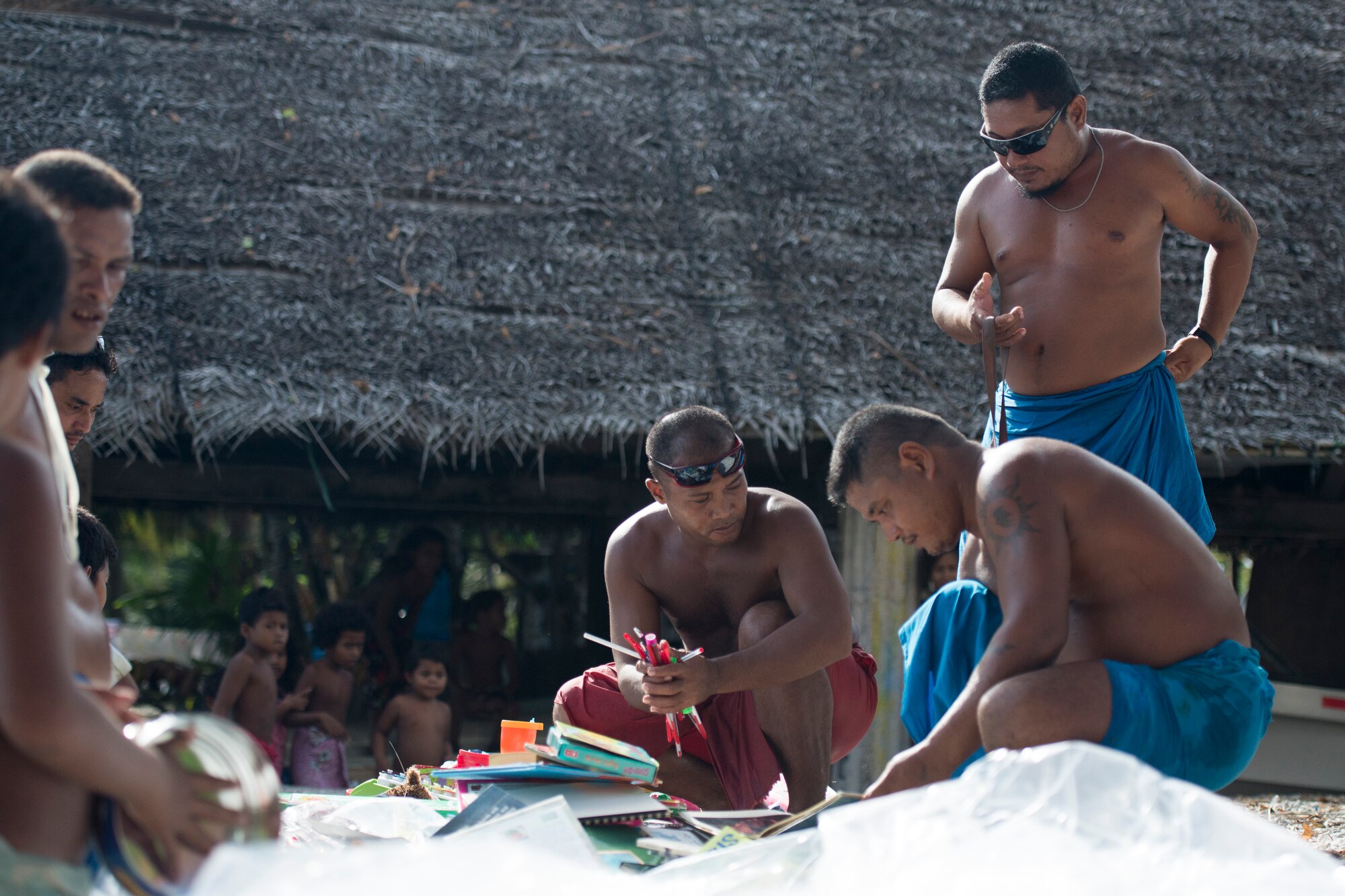 Men sort through items received from a package during Operation Christmas Drop at Ulithi Atoll, Micronesia, Dec. 9, 2014. Items are divided among men, women, children and their school. (U.S. Air Force photo by Staff Sgt. Cody H. Ramirez/Released)