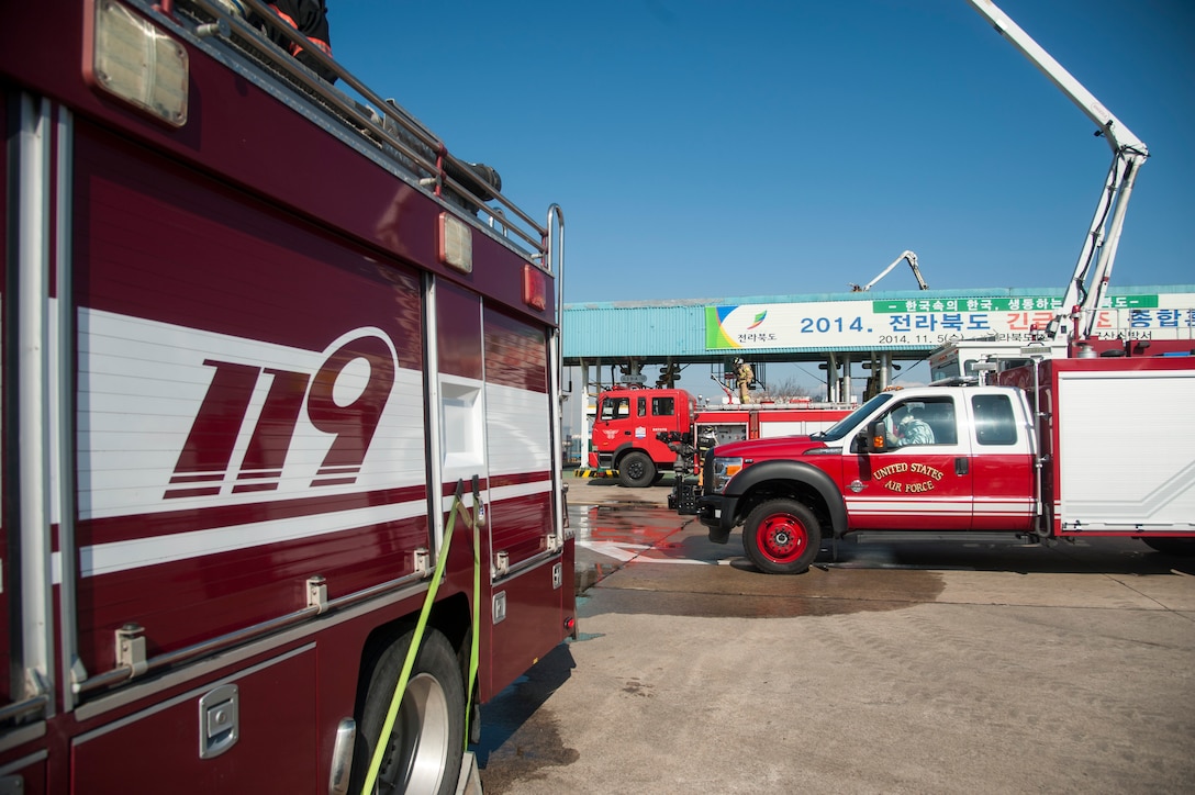 Kunsan Air Base firefighters and Gunsan City Fire Fighters extinguish a simulated fire during an emergency relief exercise in Gunsan City, Republic of Korea, Nov. 5, 2014. The purpose of this exercise was to establish an incident command system and to enhance capabilities to respond to emergencies and large disasters. (U.S. Air Force photo by Senior Airman Taylor Curry/Released) 