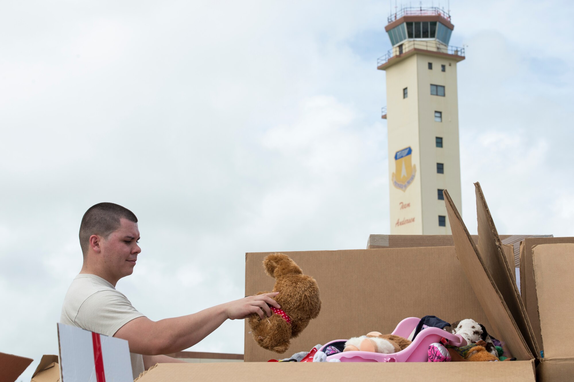 Staff Sgt. Joshua Correa, 515th Combat Mobility Flight, places toys into a crate while sorting donations for Operation Christmas Drop at Andersen Air Force Base, Guam, Dec. 3, 2014. Toys are a rarity in the remote islands of the Pacific, so sorting them ensures each island receives their fair share of the donations. U.S. Air Force photo by Staff Sgt. Cody H. Ramirez/Released) 