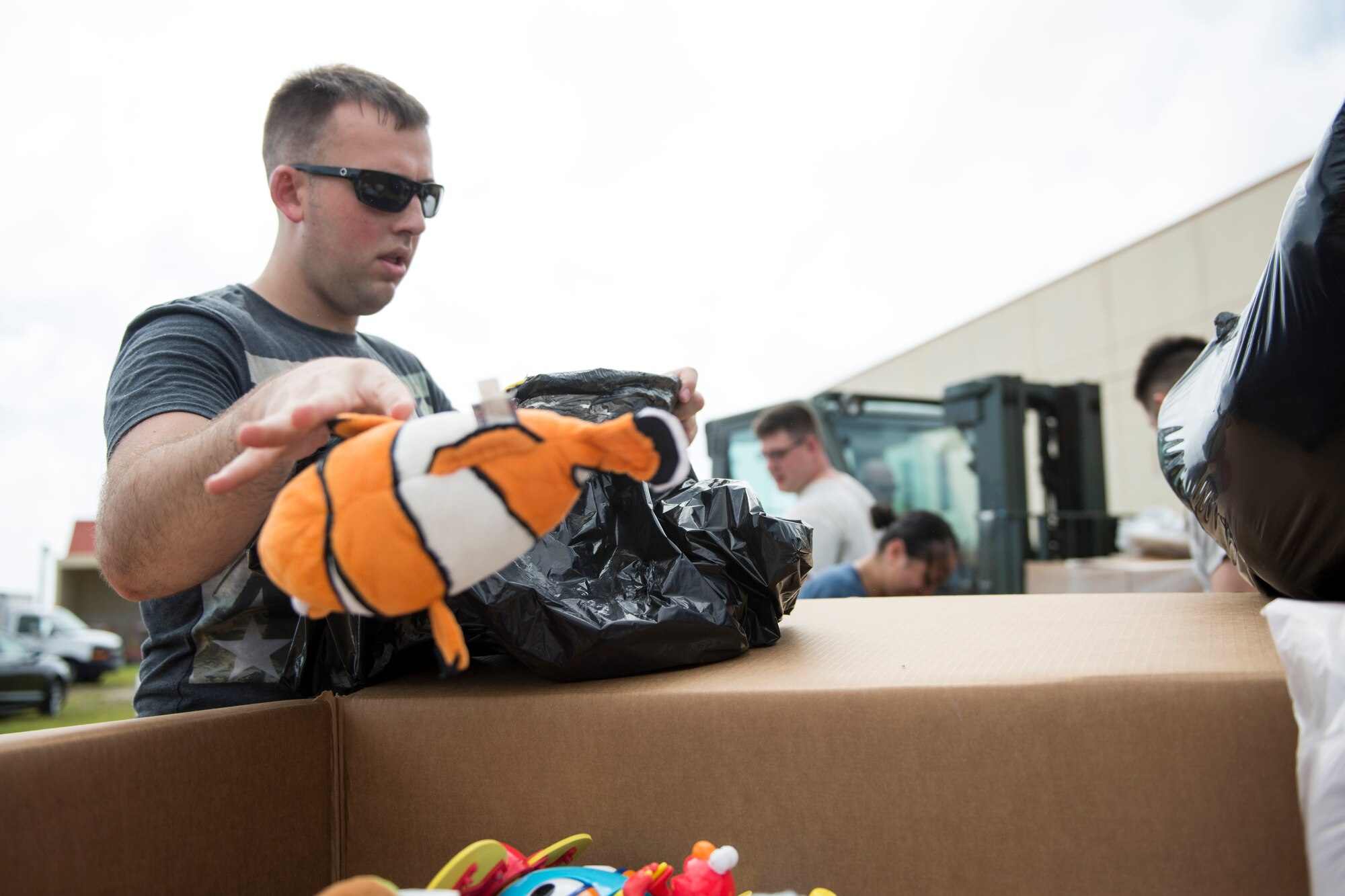 Airman 1st Class James Kephart, 644th Combat Communication Squadron, places toys into a designated box while sorting donations for Operation Christmas Drop at Andersen Air Force Base, Guam, Dec. 03, 2014. James was one of 25 volunteers who sorted 50,000 pounds of donated items before they were packaged into bundles. (U.S. Air Force photo by Staff Sgt. Cody H. Ramirez/Released)