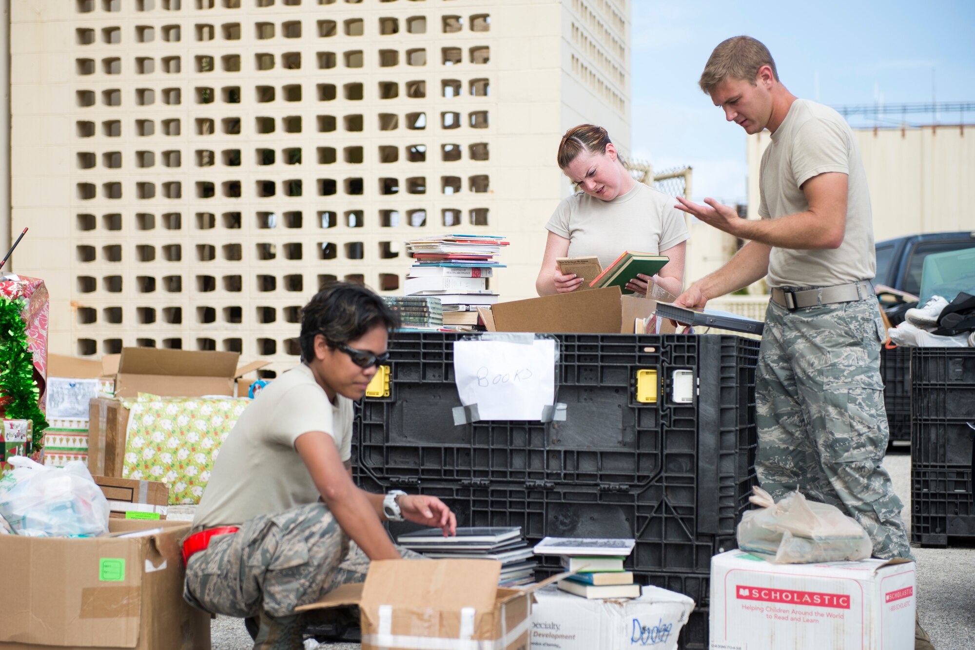Volunteers with the 734th Air Mobility Squadron and 36 Logistical Readiness Squadron sort through donations for Operation Christmas Drop at Andersen Air Force Base, Guam, Dec. 03, 2014. More than 25 volunteers sorted 50,000 pounds of donated goods that day. (U.S. Air Force photo by Staff Sgt. Cody H. Ramirez/Released)
