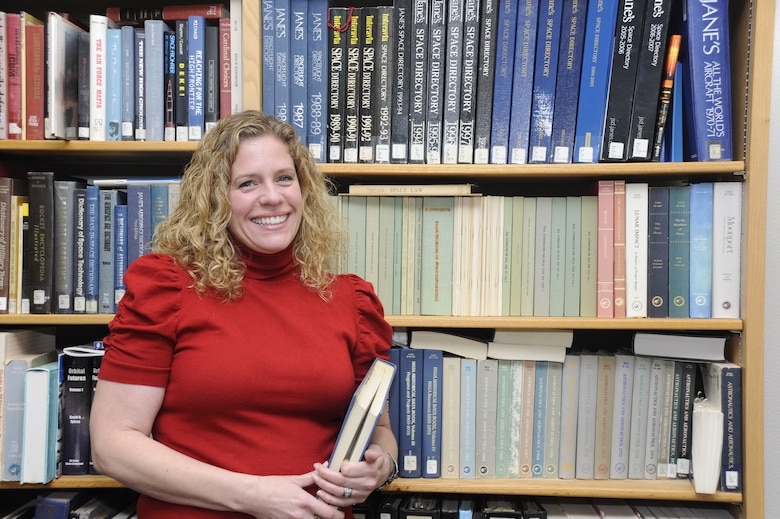 Shawn Riem, 30th Space Wing historian, poses in front of a bookshelf full of archived material, Dec. 16, 2014, Vandenberg Air Force Base, Calif. Riem’s personal mission as wing historian is to capture the base's exciting history and heritage and make it readily accessible to all members of the wing. (U.S. Air Force photo by Airman Robert J. Volio/Released)