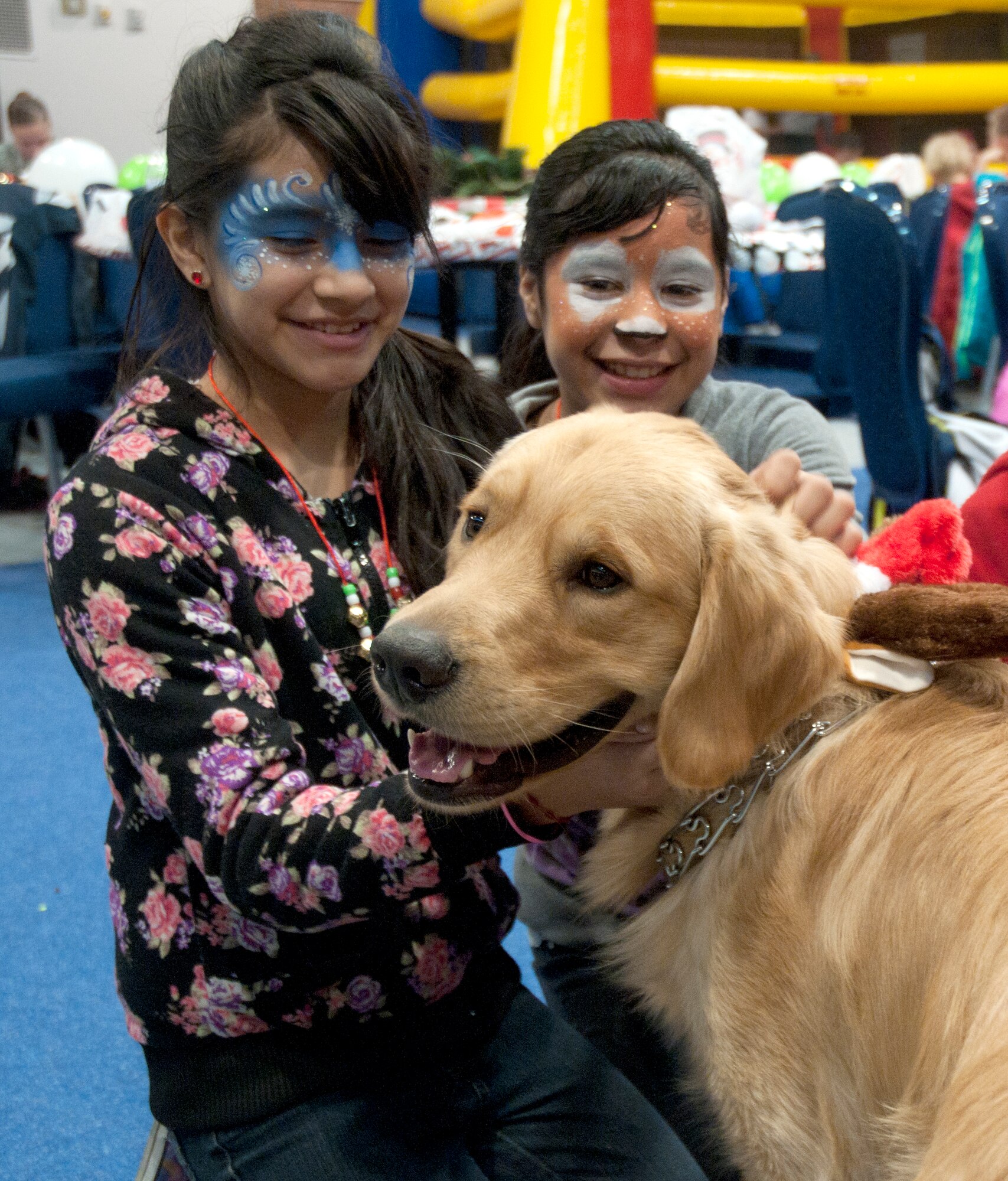 Children from Operation Provide Joy pet Zeke, the dog of Staff Sgt. Ryan Hunt, 90th Operations Squadron mission integration non-commissioned officer in charge, in the Fall Hall Community Center Dec. 13, 2014, on F.E. Warren Air Force Base, Wyo. Zeke was dressed as Rudolf to bring joy to the children at the event. (U.S. Air Force photo/Airman 1st Class Malcolm Mayfield)
