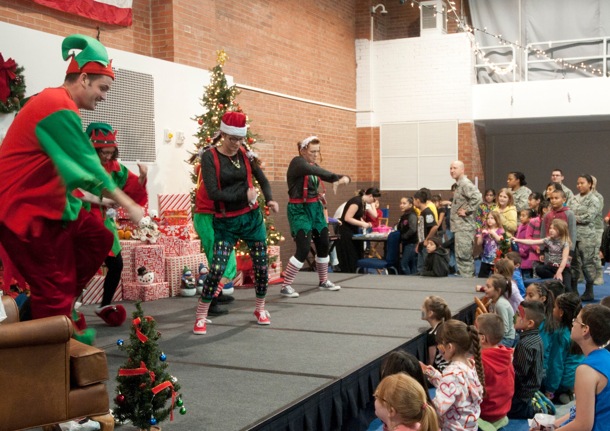 Volunteers, dressed as elves, have a dance-off at Operation Provide Joy Dec. 13, 2014, in the Fall Hall Community Center on F.E. Warren Air Force Base, Wyo. The dance-off was one of the events shown to the children along with a magic show and an appearance of Santa Claus. (U.S. Air Force photo/Airman 1st Class Malcolm Mayfield)