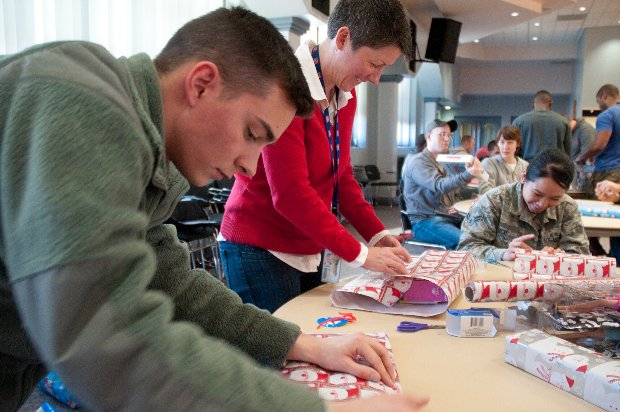 Airman 1st Class Eric Feigner, 90th Logistics Readiness Squadron vehicle management and analysis technician; Christine Ramler, 90th Medical Group credential/risk/quality manager; and Airman 1st Class April Tucay, 90th Medical Operations Squadron dental technician; wrap presents for Operation Provide Joy Dec. 12, 2014, in the Pronghorn Center on F.E. Warren Air Force Base, Wyo. The event provided more than 2,000 toys that were divided among 79 children from the local community. (U.S. Air Force photo/Airman 1st Class Malcolm Mayfield)