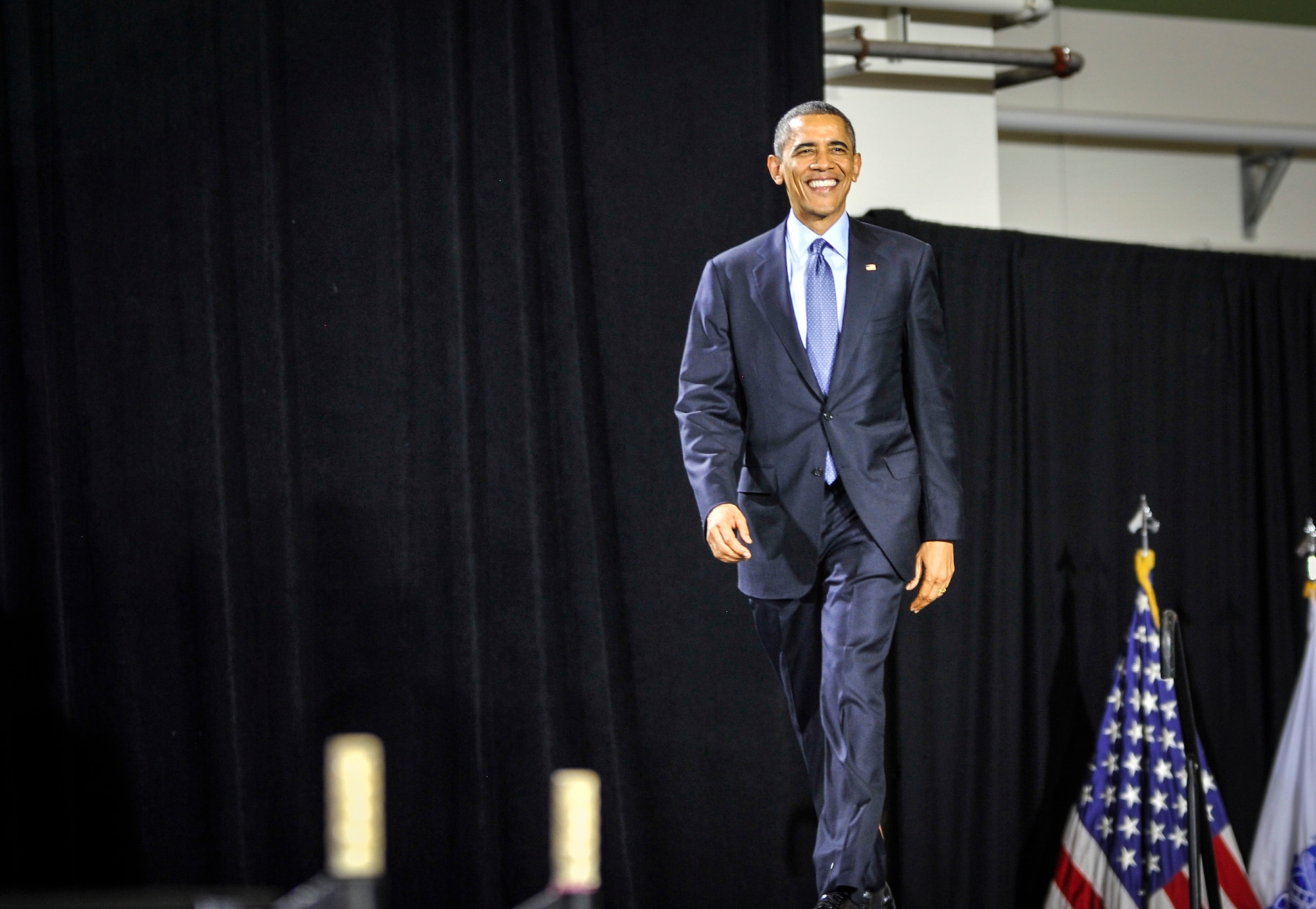 United States of America President Barack Obama walks onto a stage during a visit to Joint Base McGuire-Dix-Lakehurst, N.J., Dec. 15, 2014. The president visited the joint base to express his gratitude to service members and Department of Defense civilians for serving their country. (U.S. Air Force photo by Staff Sgt. Scott Saldukas/Released)