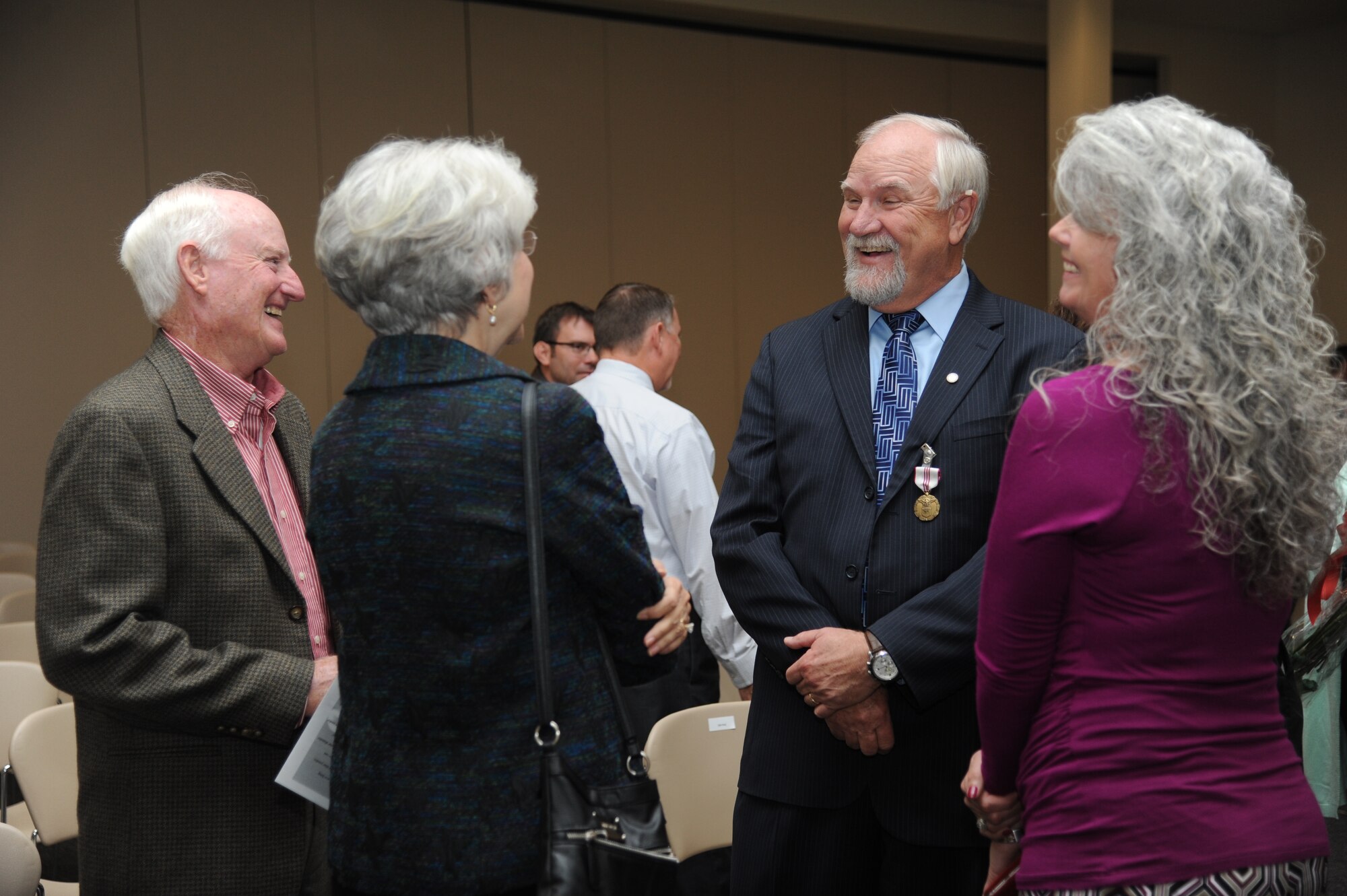 Walter Hack, Jr., 2nd Air Force technical training operations center strategy division chief, is congratulated by friends following a retirement ceremony Dec. 15, 2014, at the Roberts Consolidated Maintenance Facility, Keesler Air Force Base, Miss.  Hack retired with more than 42 years of combined service.  (U.S. Air Force photo by Kemberly Groue)