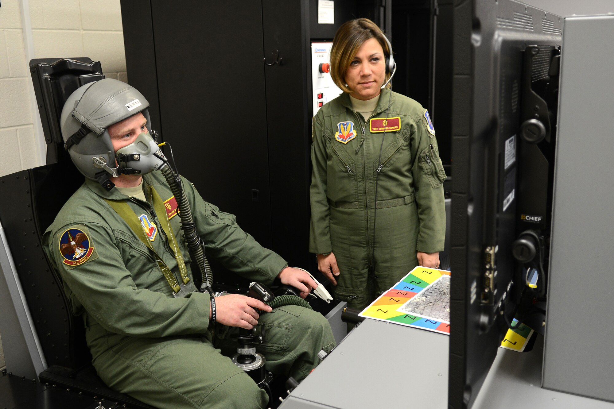 U.S. Air Force Tech. Sgt. Jennifer Kernan, 633rd Aerospace Medical Squadron flight chief, practices training Senior Airman Mason Wyman, 633rd AMS physiology technician, on a Reduced Oxygen Breathing Device at Langley Air Force Base, Va., Dec. 11, 2014. The ROBDs can replicate the F-22 Raptor and T-38 Talon, among other planes, to accommodate different training objectives for U.S. military pilots and air crew members from the Hampton Roads area. (U.S. Air Force photo by Airman 1st Class Devin Scott Michaels/Released)