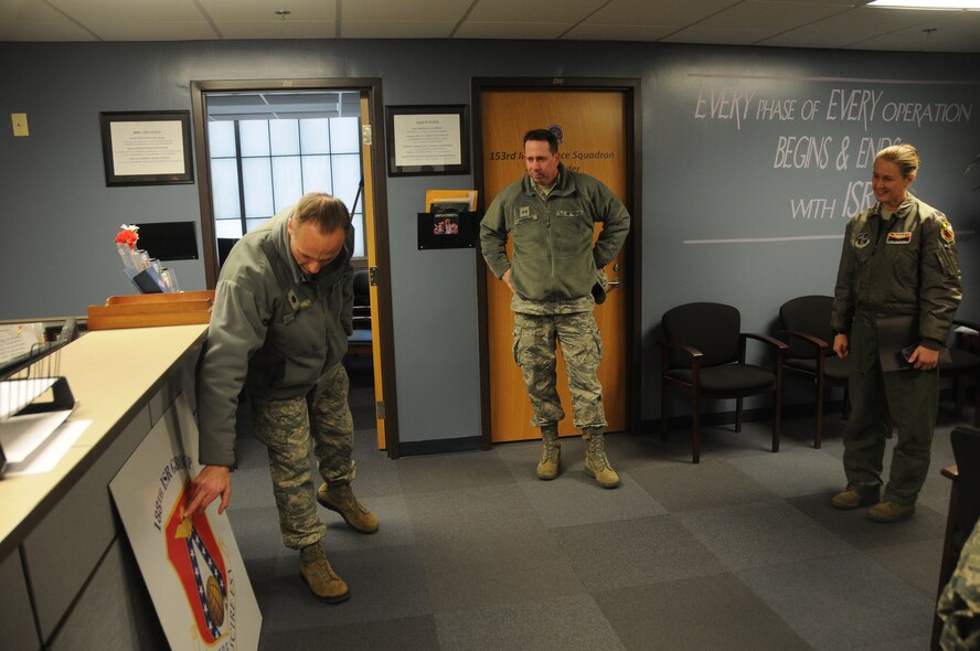 Lt. Col. Robert Kinney, commander of the 188th Intelligence, Surveillance and Reconnaissance Group, shows plans for a potential new group patch to Maj. Gen. John Shanahan, commander of the 25th Air Force, and Col. Bobbi Doorenbos, commander of the 214th Reconnaissance Group, at Ebbing Air National Guard Base, Fort Smith, Ark., Dec. 11, 2014. Shanahan’s visit encompassed seeing and understanding how the wing’s new mission aligns with the 25th AF. (U.S. Air National Guard photo by Airman 1st Class Cody Martin/released)