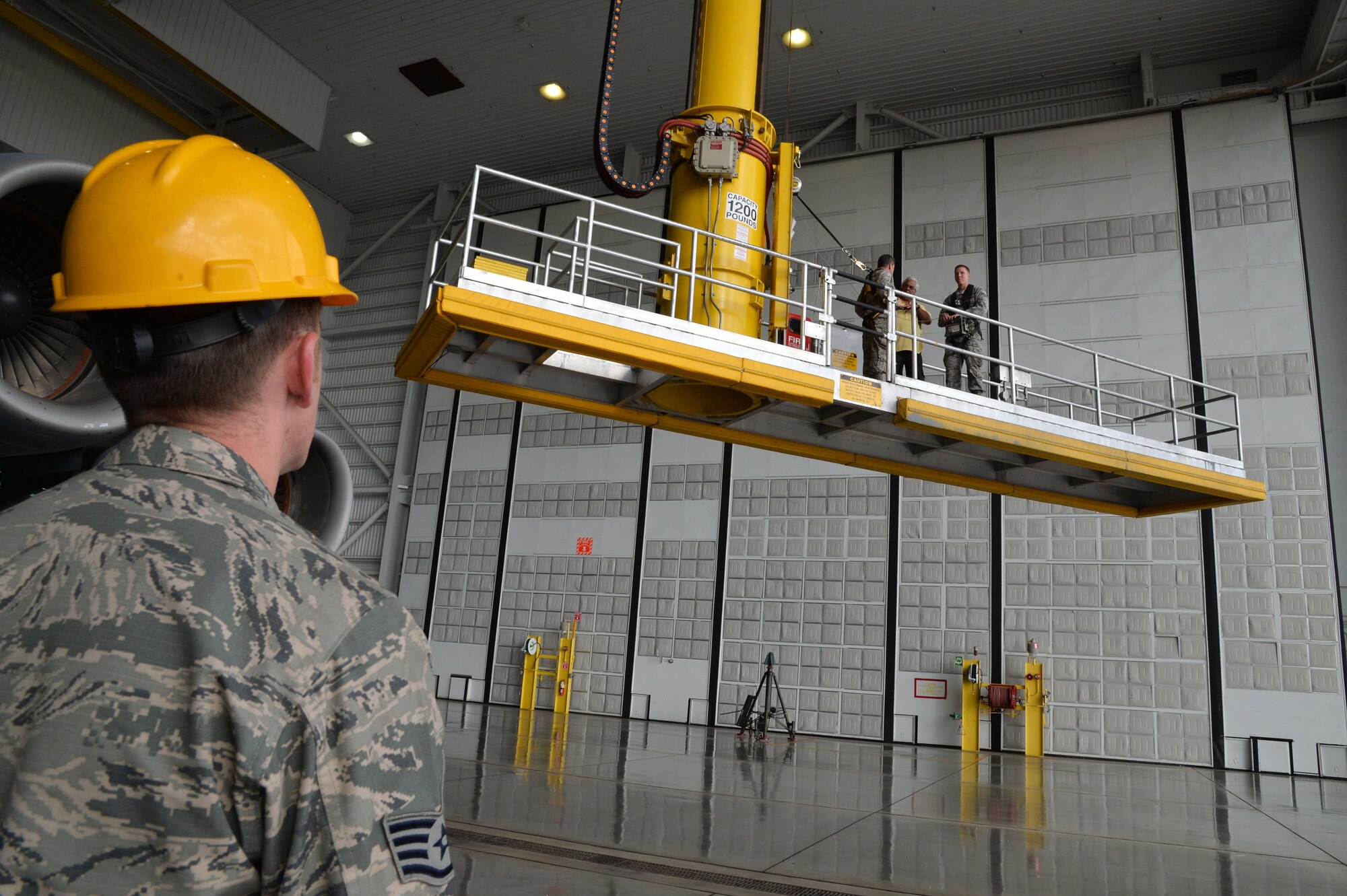Lt. Gen. Russell Handy, 11th Air Force commander, receives a brief from 15th Maintenance Group members aboard a lift at Joint Base Pearl Harbor-Hickam, Hawaii, Dec. 12, 2014. Handy rode the lift above a C-17 Globemaster III. In addition to his tour, Handy also hosted a Wing all-call, addressing Air Force and Pacific-region topics of interest. (U.S. Air Force photo by Staff Sgt. Alexander Martinez/Released)      