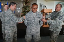 Airman 1st Class Clifton Giles, 647th Security Forces Squadron, receives his senior airman stripes from Lt. Gen. Russell Handy, 11th Air Force commander, and Chief Master Sgt. James Smith, 15th Wing command chief, during an all-call at Joint Base Pearl Harbor-Hickam, Hawaii, Dec. 12, 2014. Handy thanked the audience for their hard work, and addressed Air Force and Pacific-region topics of interest. In addition to the all-call, Handy met with group and squadron leadership and toured base units. (U.S. Air Force photo by Staff Sgt. Alexander Martinez/Released)      