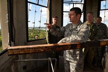 Lt. Gen. Russell Handy, 11th Air Force commander, peers out of the Hickam Water Tower window toward the city of Honolulu while on the observation deck of the structure at Joint Base Pearl Harbor-Hickam, Hawaii, Dec. 12, 2014. 647th Civil Engineer Squadron members showed Handy the process of outfitting the tower with holiday lights and decorations. During his visit, Handy hosted a Wing all-call, met with group and squadron leadership and toured base units. (U.S. Air Force photo by Staff Sgt. Alexander Martinez/Released)      