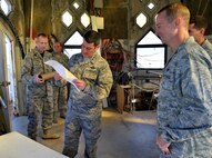 Lt. Gen. Russell Handy, 11th Air Force commander, receives a copy of the original blueprint of the Hickam Water Tower while on the observation deck of the structure at Joint Base Pearl Harbor-Hickam, Hawaii, Dec. 12, 2014. 647th Civil Engineer Squadron members showed Handy the process of outfitting the tower with holiday lights and decorations. During his visit, Handy hosted a Wing all-call, met with group and squadron leadership and toured base units. (U.S. Air Force photo by Staff Sgt. Alexander Martinez/Released)      