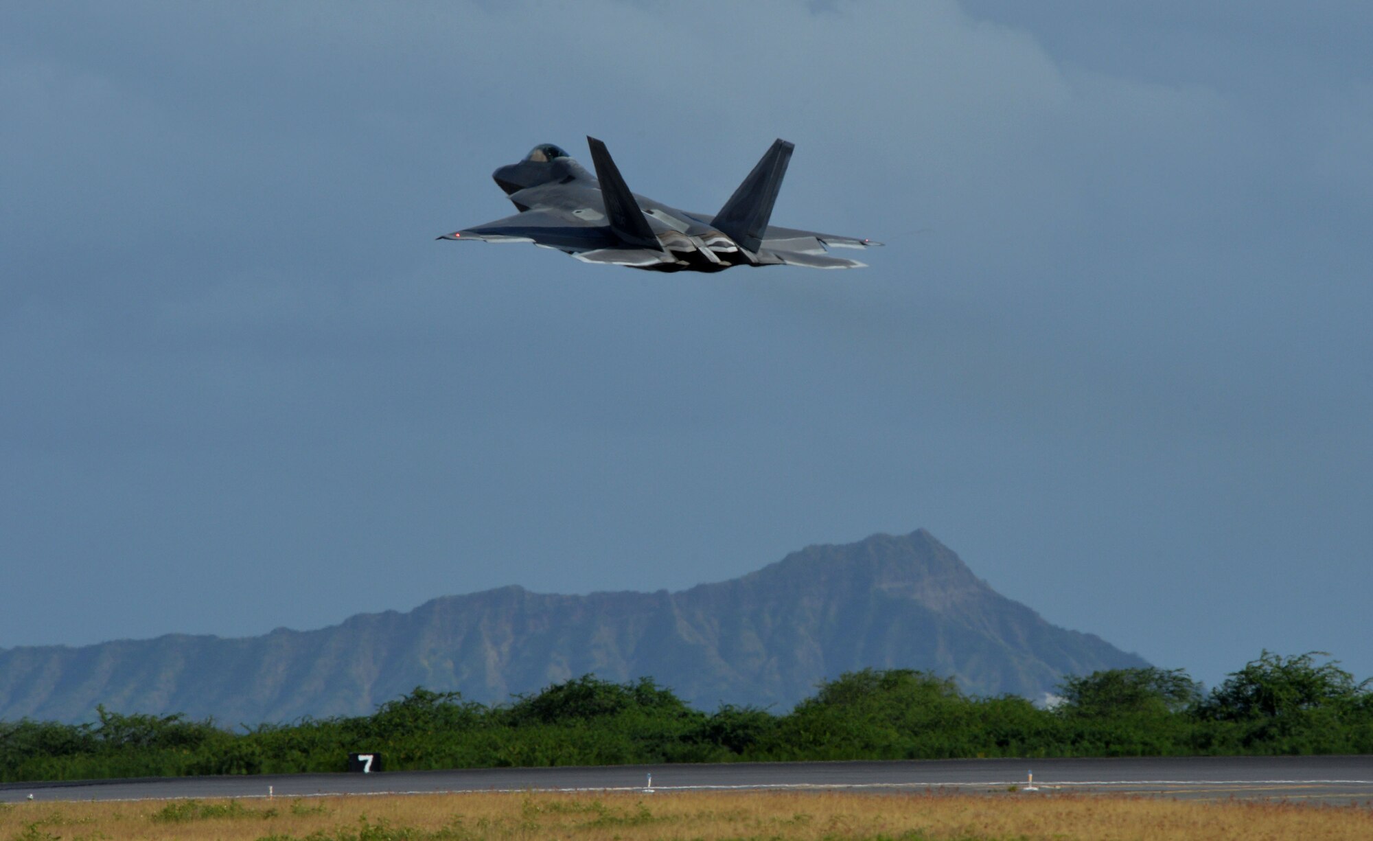 An F-22 Raptor piloted by Lt. Gen. Russell Handy, 11th Air Force commander, takes off from the flightline with Diamond Head in the background at Joint Base Pearl Harbor-Hickam, Hawaii, Dec. 11, 2014. During his visit, Handy hosted a Wing all-call, met with group and squadron leadership and toured base units. (U.S. Air Force photo by Staff Sgt. Alexander Martinez/Released)      