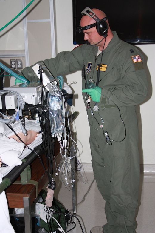 Capt. Andrew Ray Severns, an Air Force critical care nurse, monitors a "patient" during Critical Care Air Transport Team (CCATT) Simulation Day training in Walter Reed Bethesda simulation center on Dec. 11. Physicians, nurses and respiratory therapists were able to hone their critical care skills on life-like manikins using virtual reality machines and equipment in the high-tech, state-of-the-art simulation center. (Photo by Bernard S. Little)