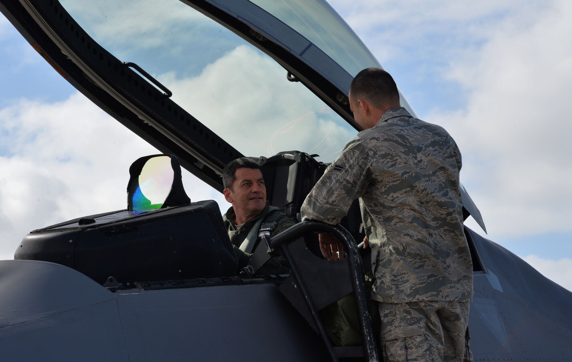 Lt. Gen. Russell Handy, 11th Air Force commander, speaks with Airman 1st Class Tyler Moncecchi, 15th Aircraft Maintenance Squadron, aboard an F-22 Raptor before a mission at Joint Base Pearl Harbor-Hickam, Hawaii, Dec. 11, 2014. During his visit, Handy hosted a Wing all-call, met with group and squadron leadership and toured base units. (U.S. Air Force photo by Staff Sgt. Alexander Martinez/Released)      