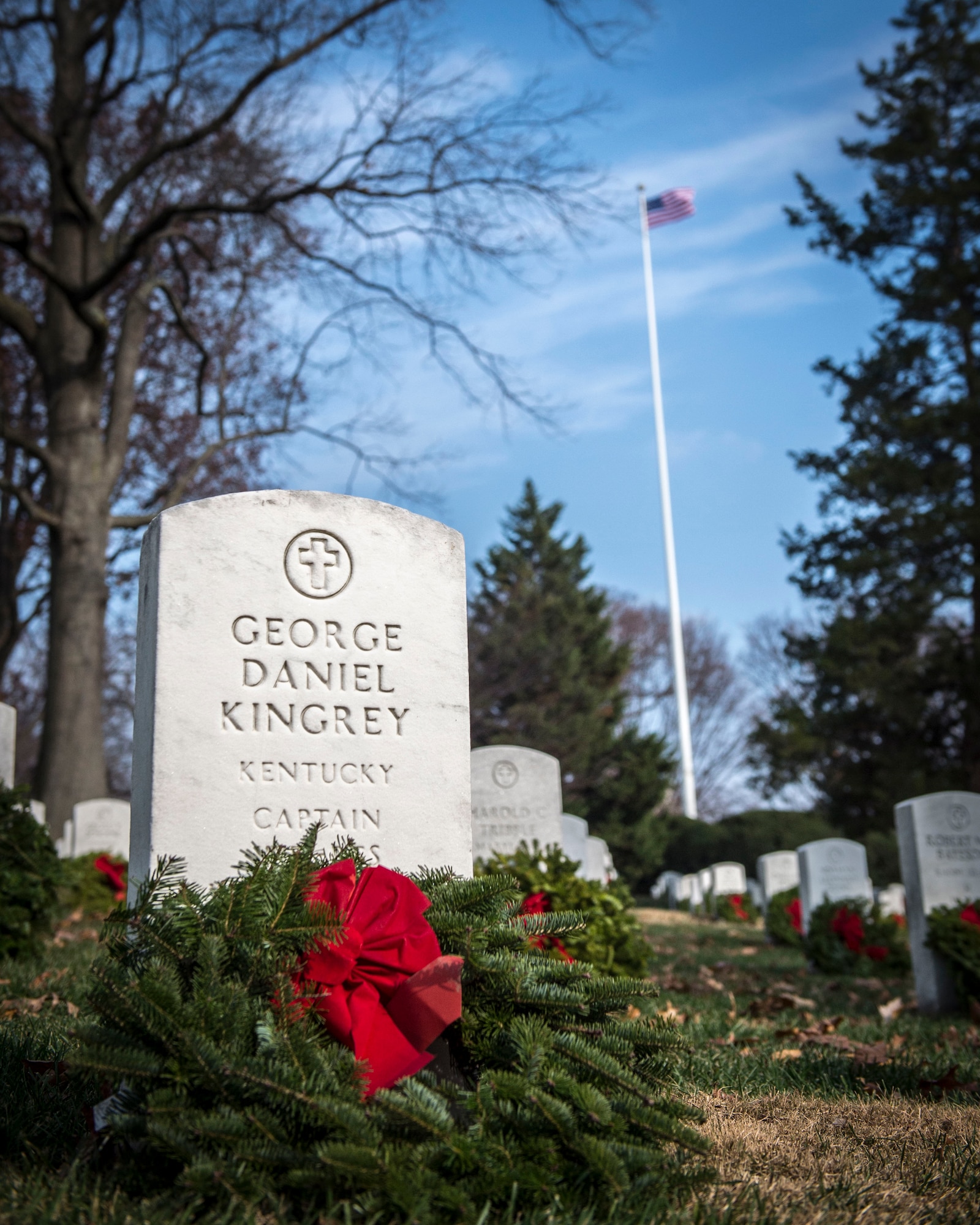 A holiday wreath adorns the grave of Capt. George Kingrey at Arlington National Cemetery, Dec. 13, 2014. Volunteers from Dover Air Force Base, Delaware, teamed up with Wreaths across America to place holiday wreath on every grave throughout the national cemetery. (U.S. Air Force photo/Capt. Ray Geoffroy)