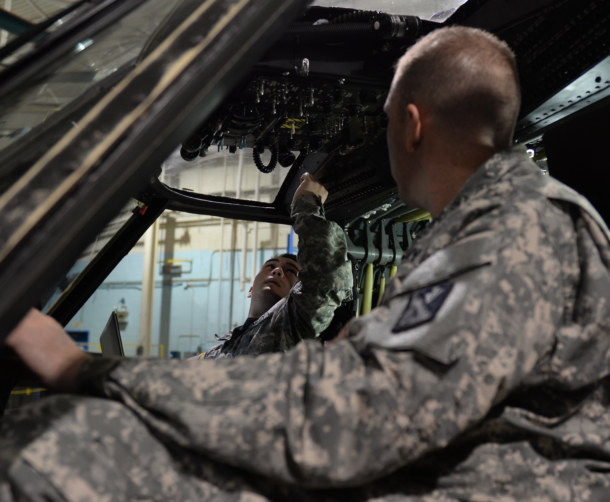 U.S. Army Staff Sgt. Kevin Shaffer, Charlie Company, 1st Battalion, 210th Aviation Regiment, 128th Aviation Brigade instructor, observes Pvt. David Benfer, 128th Avn. Bde. aircraft electrical student, troubleshoot the Caution Advisory System on a UH-60 Blackhawk trainer model helicopter at Fort Eustis, Va., Dec. 10, 2014. Shaffer teaches between 30 and 40 students each year, some who request him as their mentor after they graduate. (U.S. Air Force photo by Staff Sgt. Teresa J. Cleveland/Released)