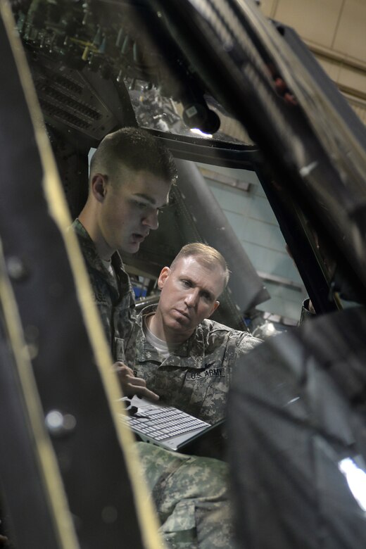 U.S. Army Staff Sgt. Kevin Shaffer, Charlie Company, 1st Battalion, 210th Aviation Regiment, 128th Aviation Brigade instructor, observes Pvt. Timothy Beasley, 128th Avn. Bde. aircraft electrical student, troubleshoot the Caution Advisory System on a UH-60 Blackhawk trainer model helicopter at Fort Eustis, Va., Dec. 10, 2014. Shaffer said he hopes his students learn as much as possible regarding maintaining an aircraft, but that they ask for help if they are not sure how to do something. (U.S. Air Force photo by Staff Sgt. Teresa J. Cleveland/Released)