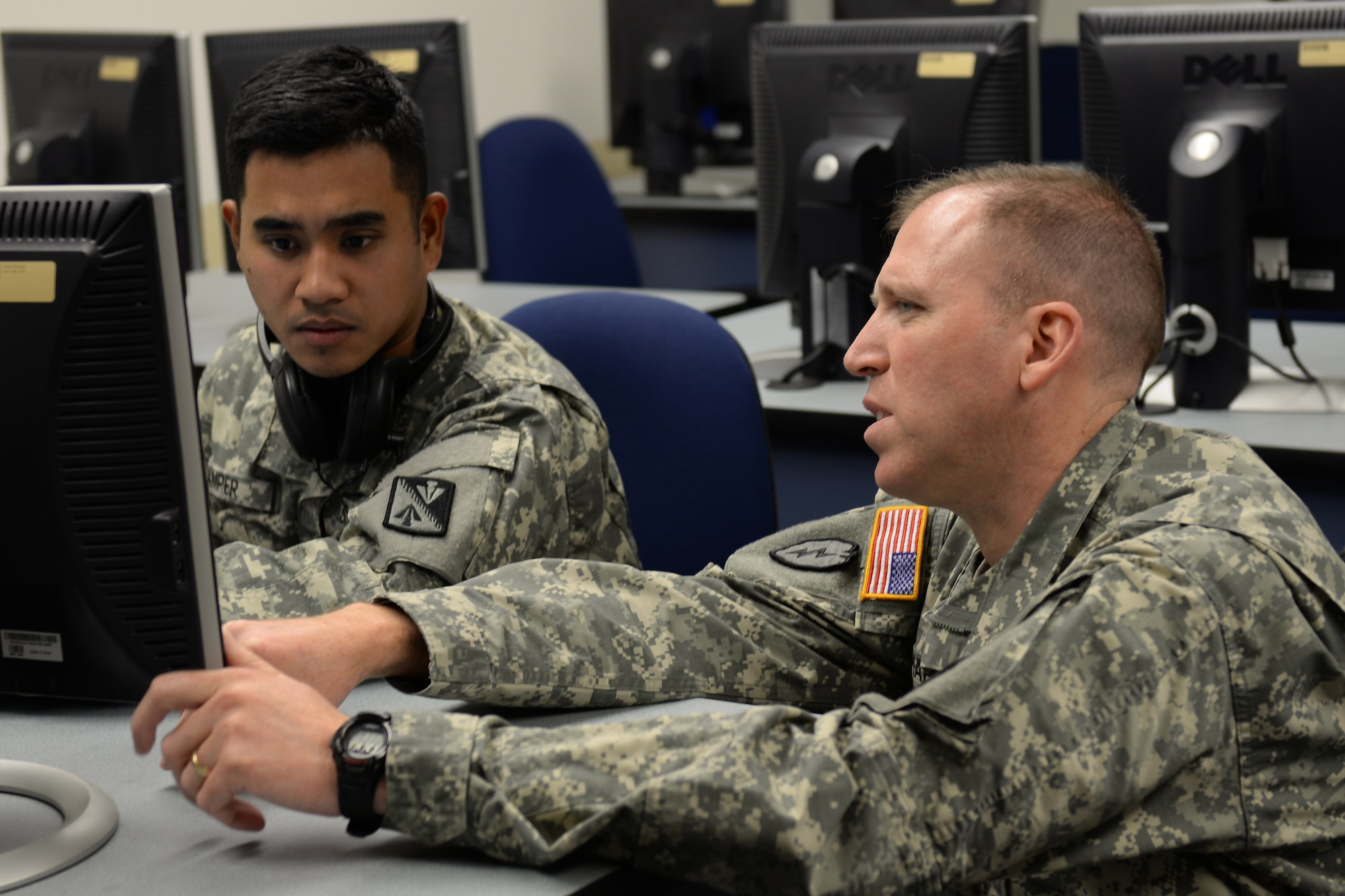 U.S. Army Staff Sgt. Kevin Shaffer, Charlie Company, 1st Battalion, 210th Aviation Regiment, 128th Aviation Brigade instructor, discusses a computer simulation with Spc. Sherman Amper, 128th Avn. Bde.  aircraft electrical student at Fort Eustis, Va., Dec. 10, 2014. Students work on simulations in the classroom before they get hands-on experience maintaining the UH-60 Blackhawk and CH-47 Chinook helicopters. (U.S. Air Force photo by Staff Sgt. Teresa J. Cleveland/Released)