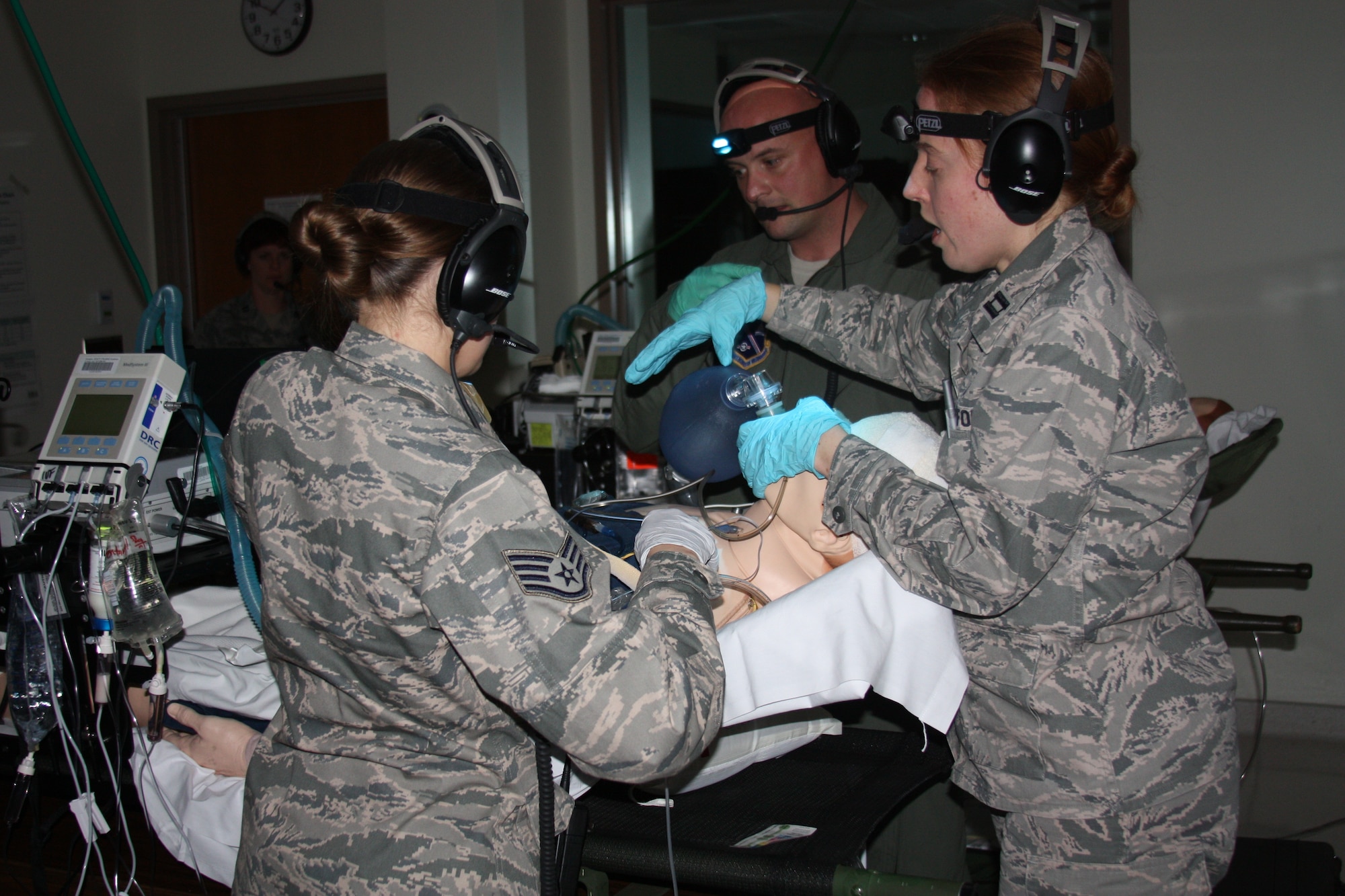 Clockwise, Air Force Capt. Andrew Ray Severns, Capt. (Dr.) Katherine Ellis and Staff Sgt. Jamie Bucher participate in Critical Care Air Transport Team (CCATT) Simulation Day training in Walter Reed Bethesda simulation center on Dec. 11. Physicians, nurses and respiratory therapists were able to hone their critical care skills on life-like manikins using virtual reality machines and equipment in the high-tech, state-of-the-art simulation center. (Photo by Bernard S. Little)