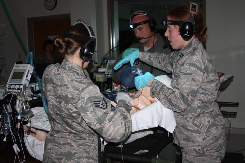 Clockwise, Air Force Capt. Andrew Ray Severns, Capt. (Dr.) Katherine Ellis and Staff Sgt. Jamie Bucher participate in Critical Care Air Transport Team (CCATT) Simulation Day training in Walter Reed Bethesda simulation center on Dec. 11. Physicians, nurses and respiratory therapists were able to hone their critical care skills on life-like manikins using virtual reality machines and equipment in the high-tech, state-of-the-art simulation center. (Photo by Bernard S. Little)