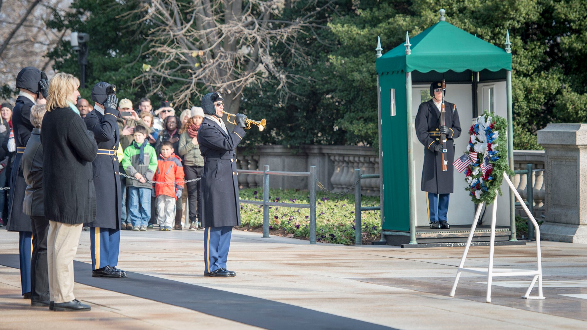 A Tomb Guard plays taps during a wreath presentation at the Tomb of the Unknown Soldier at Arlington National Cemetery, Dec. 13, 2014. Approximately 150 volunteers from Dover Air Force Base, Delaware, joined thousands of service members, veterans and civilians to help place holiday wreaths on graves throughout the cemetery. (U.S. Air Force photo/Capt. Ray Geoffroy)