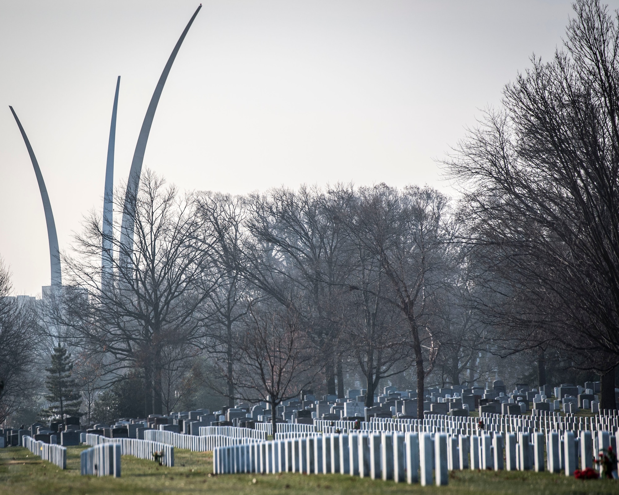 The three arcs of the Air Force Memorial rise above rows of graves at Arlington National Cemetery, Dec. 13, 2014. Approximately 150 volunteers from Dover Air Force Base, Delaware, volunteered to place holiday wreaths on graves throughout the cemetery. For many this was their first time seeing both Arlington and their service’s memorial. (U.S. Air Force photo/Capt. Ray Geoffroy)
