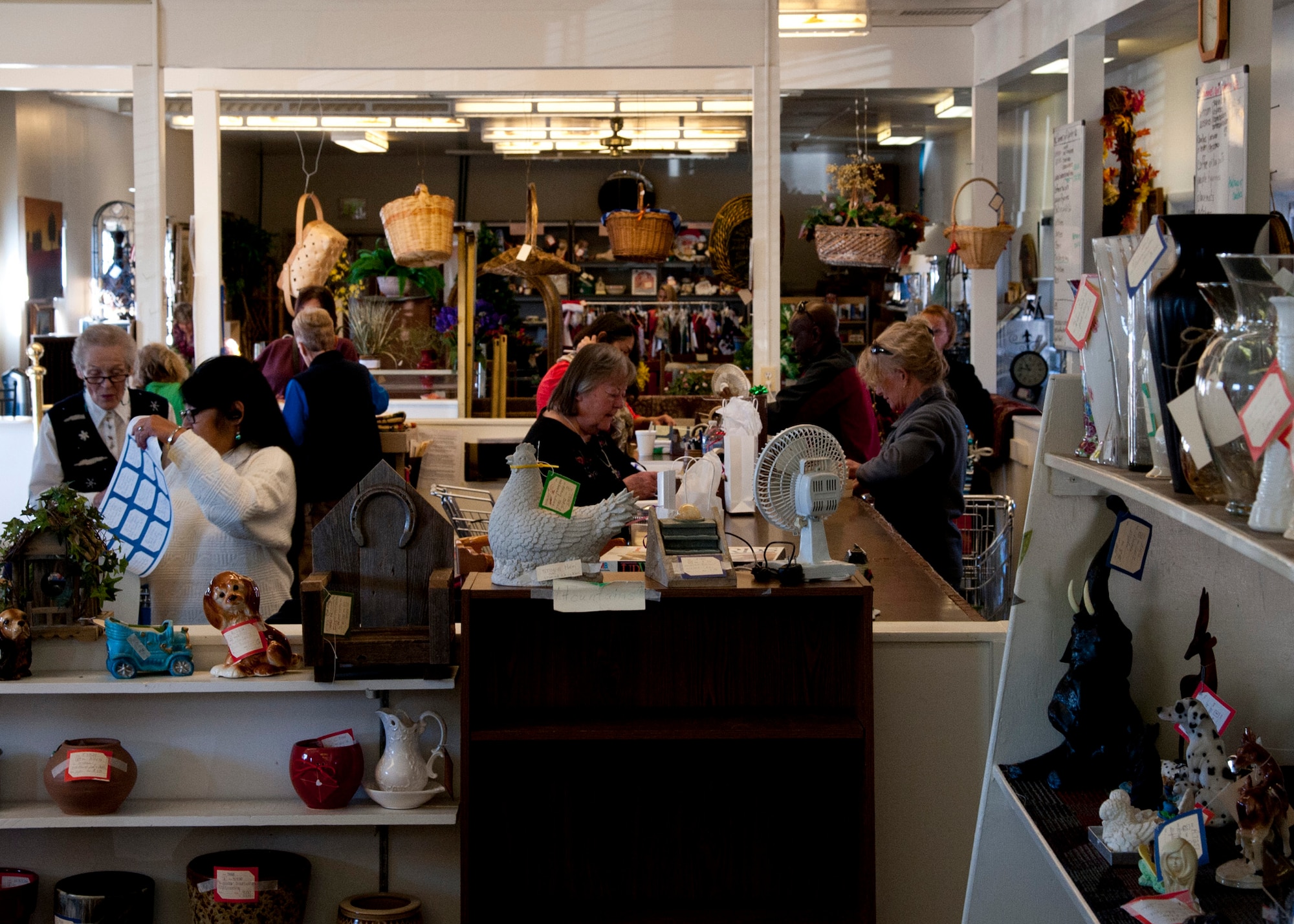 PETERSON AIR FORCE BASE, Colo. –Thrift Shop volunteers help customers check out with their new found goods in building 615, Dec. 10, 2014. The Thrift Shop is open Tuesday through Friday, 9 a.m.-2 p.m., and 10 a.m.-noon the first and third Saturday of the month. There is also a box outside the building to drop off donations any time. (U.S. Air Force photo by Senior Airman Tiffany DeNault)