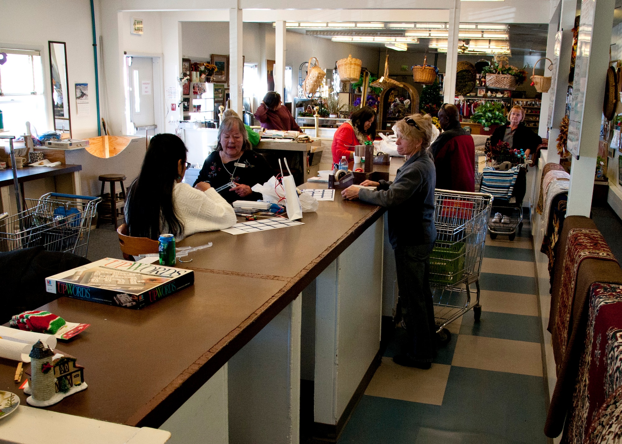 PETERSON AIR FORCE BASE, Colo. –Thrift Shop volunteers help customers check out with their new-found goods in building 615, Dec. 10, 2014. The Thrift Shop is open Tuesday through Friday, 9 a.m.-2 p.m., and 10 a.m.-noon the first and third Saturday of the month. There is also a box outside the building to drop off donations any time. (U.S. Air Force photo by Senior Airman Tiffany DeNault)