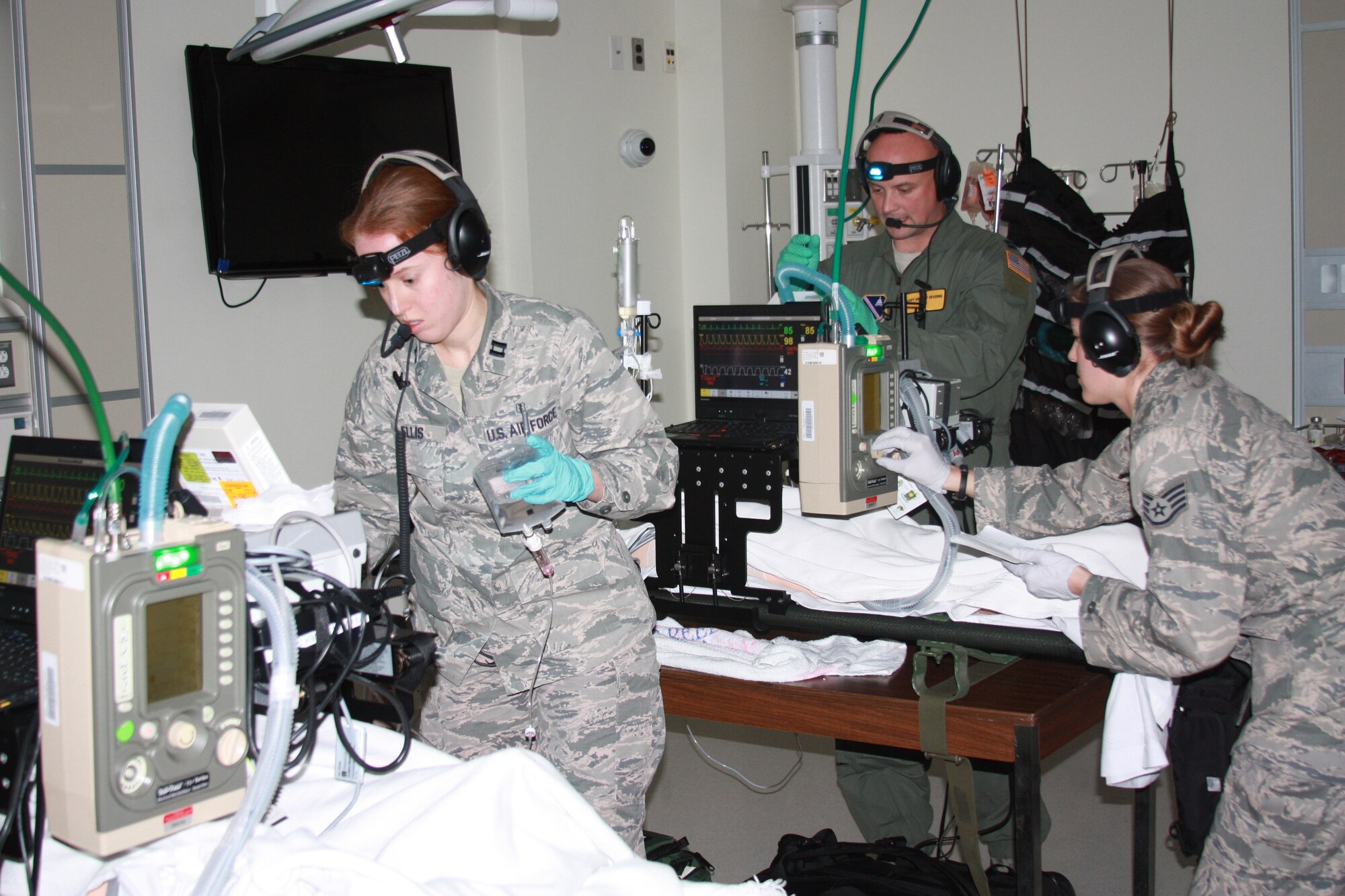 Air Force Capt. (Dr.) Katherine Ellis, Staff Sgt. Jamie Bucher and Capt. Andrew Ray Severns participate in Critical Care Air Transport Team (CCATT) Simulation Day training in Walter Reed Bethesda simulation center on Dec. 11. Air Force physicians, nurses and respiratory therapists were able to hone their critical care skills on life-like manikins using virtual reality machines and equipment in the high-tech, state-of-the-art simulation center. (Photo by Bernard S. Little)