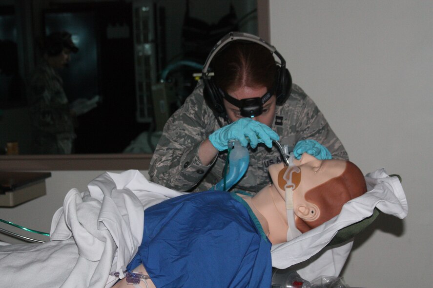 Air Force Capt. (Dr.) Katherine Ellis works to improve the breathing of "a patient" during a Critical Care Air Transport Team (CCAT) Simulation Day training exercise at Walter Reed Bethesda simulation center on Dec. 11. The "patient" had bilateral pulmonary contusions and rib fractures, as well as abdominal injuries and an injury to his left femoral artery. During the simulation, the patient developed a left sided tension pneumothorax which required decompression with a 14-gauge needle and chest tube placement, Ellis explained. (Photo by Bernard S. Little)

