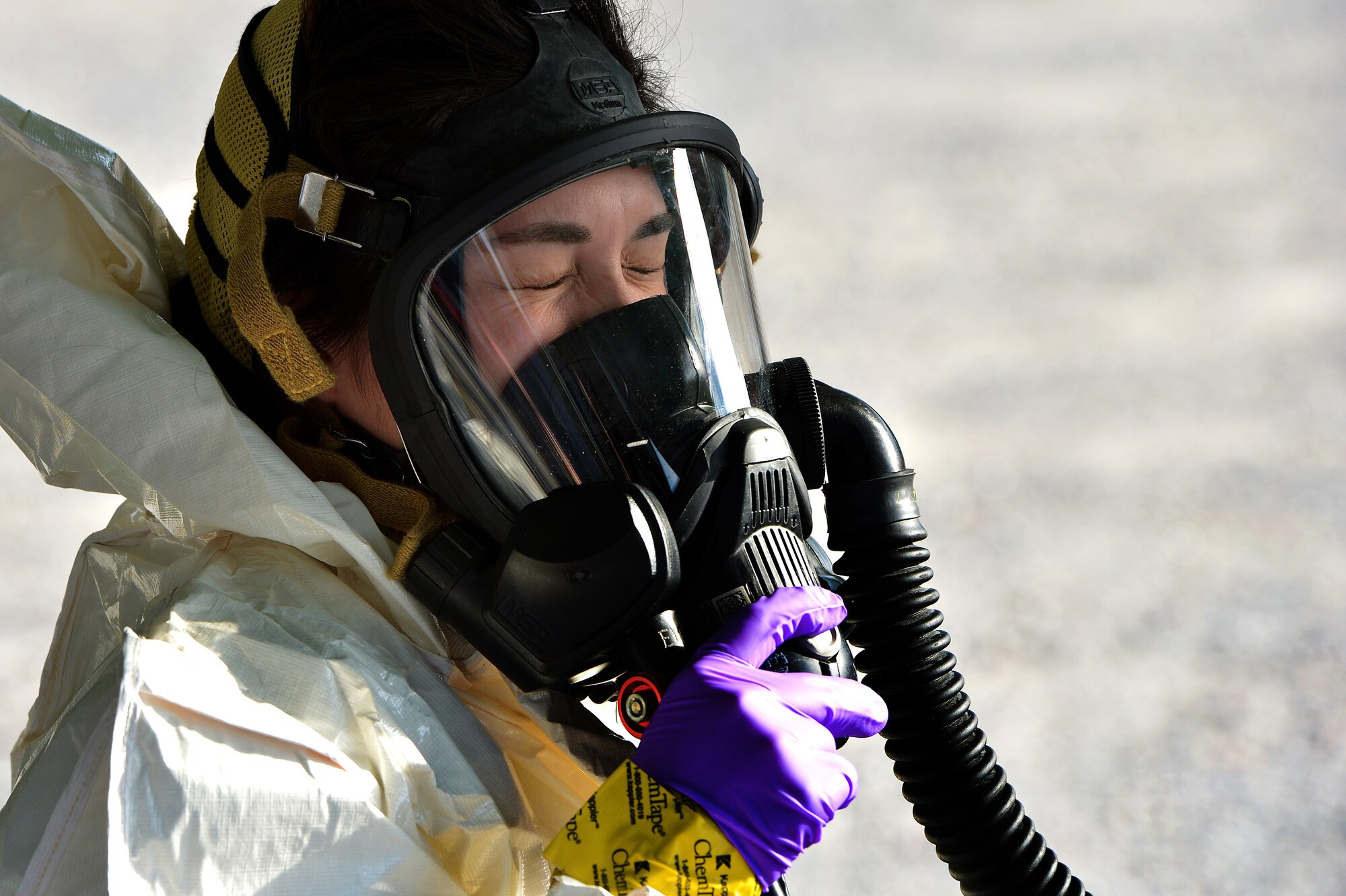 U.S. Air Force Senior Airman Chantal Hogue, 20th Civil Engineer Squadron emergency management apprentice, tests the air flow of her mask as she prepares to enter a simulated contamination zone during an integrated base emergency response capability exercise at Shaw Air Force Base, S.C., Dec. 9, 2014. The Airmen were the initial entry team and entered the simulated contamination zone fist to test for hazardous materials. (U.S. Air Force photo by Staff Sgt. Kenny Holston/Released)