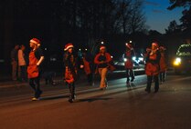 Volunteers pass out candy to members of Team Seymour lining the streets of base housing during the Santa Parade at Seymour Johnson Air Force Base, North Carolina, Dec. 13, 2014. The parade featured the Grinch, several vehicles from base agencies, and Santa Claus rounding out the procession of sights and sounds. (U.S. Air Force photo/Senior Airman Ashley J. Thum)  