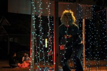 The Grinch throws out candy from behind his cage of holiday lights during the Santa Parade at Seymour Johnson Air Force Base, North Carolina, Dec. 13, 2014. The parade featured vehicles from several base agencies, dozens of volunteers passing out candy, and Santa Claus finishing up the spectacle. (U.S. Air Force photo/Senior Airman Ashley J. Thum)