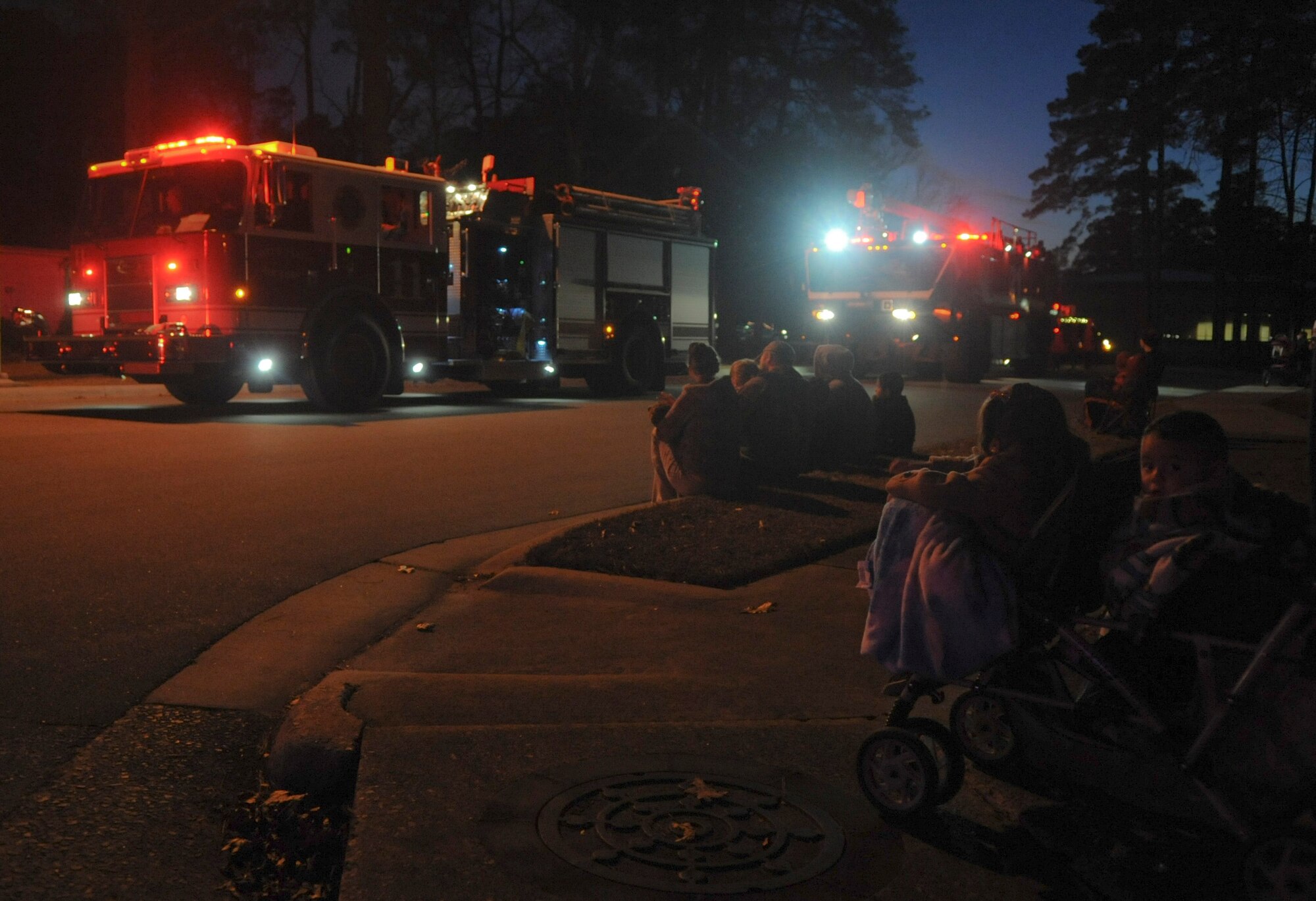 Members of Team Seymour line the streets of base housing to take in all the sights and sounds of the Santa Parade at Seymour Johnson Air Force Base, North Carolina, Dec. 13, 2014. The parade featured the Grinch, several vehicles from base agencies, dozens of volunteers passing out candy, and, of course, Santa Claus. (U.S. Air Force photo/Senior Airman Ashley J. Thum)